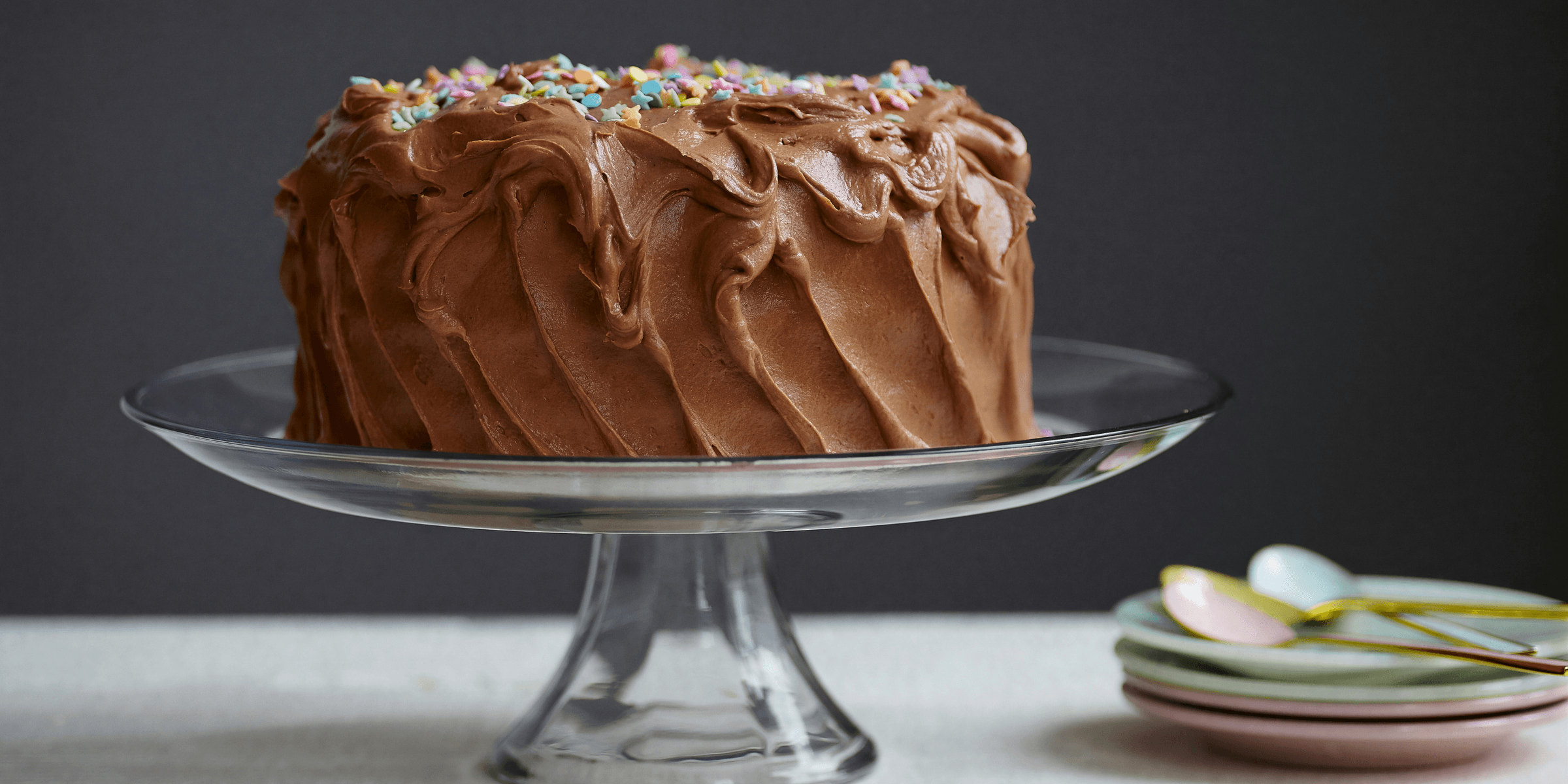 brown cake on clear glass cake stand.