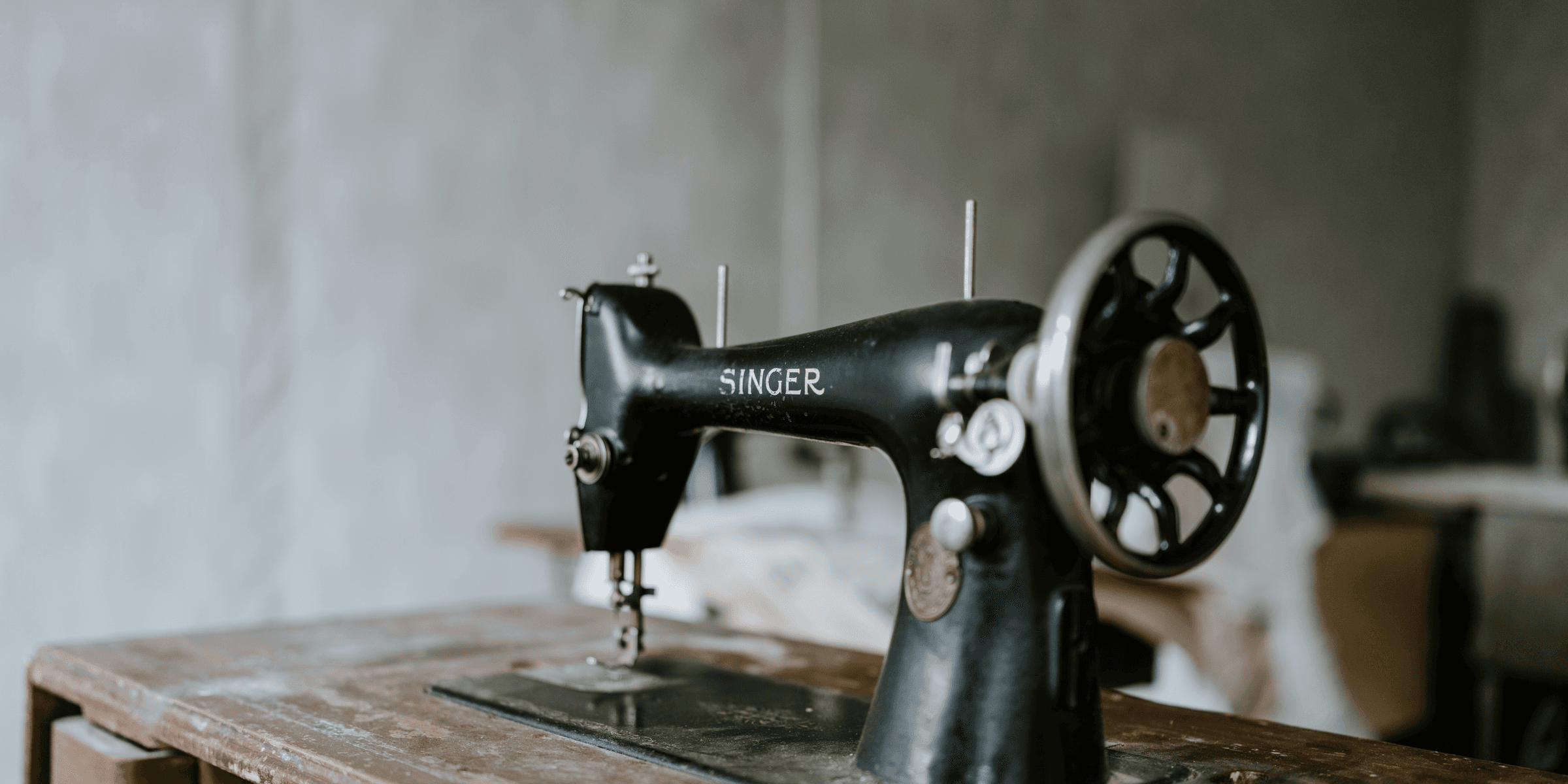 black sewing machine on brown wooden table.