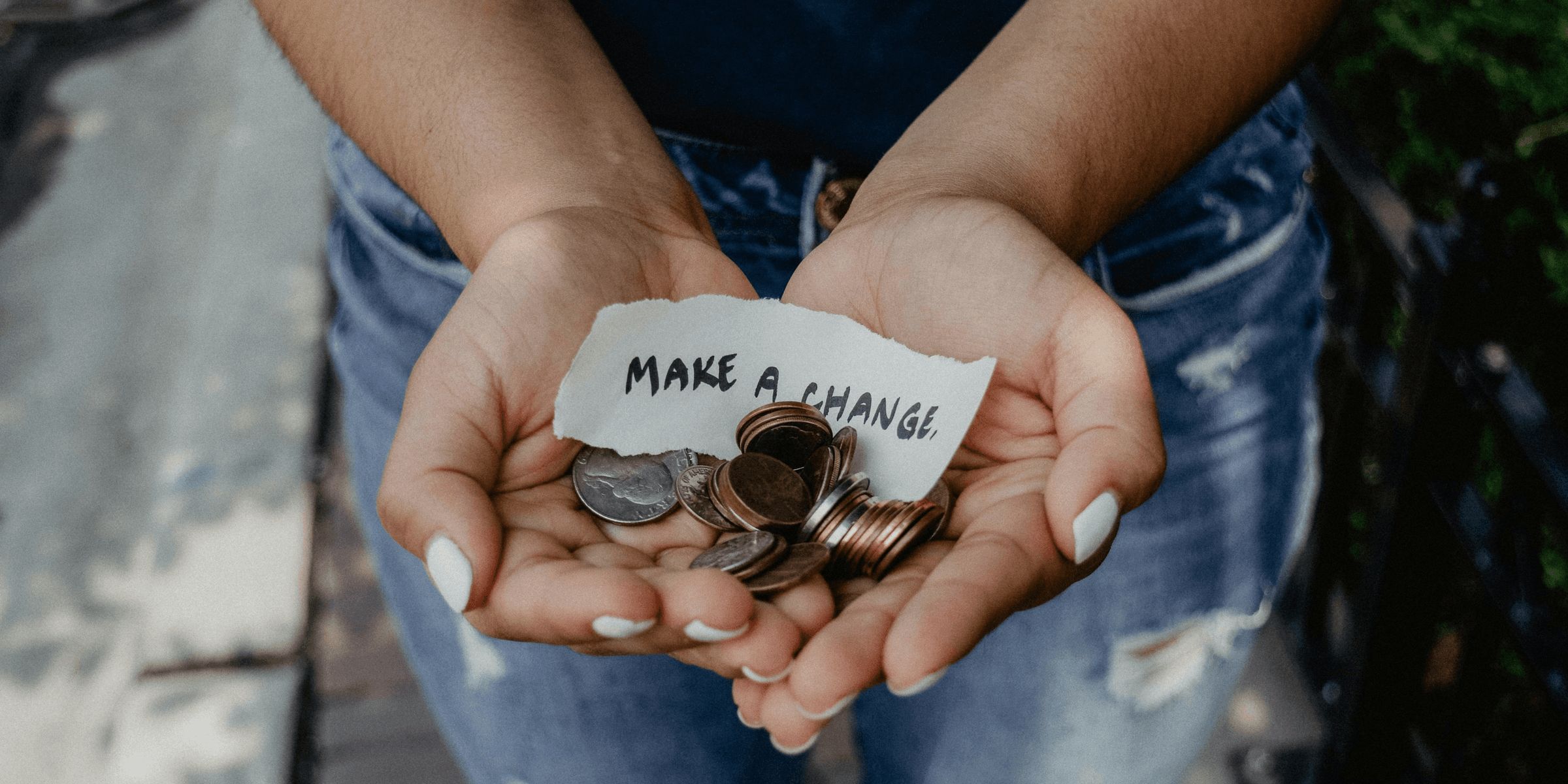 person showing both hands with make a change note and coins.