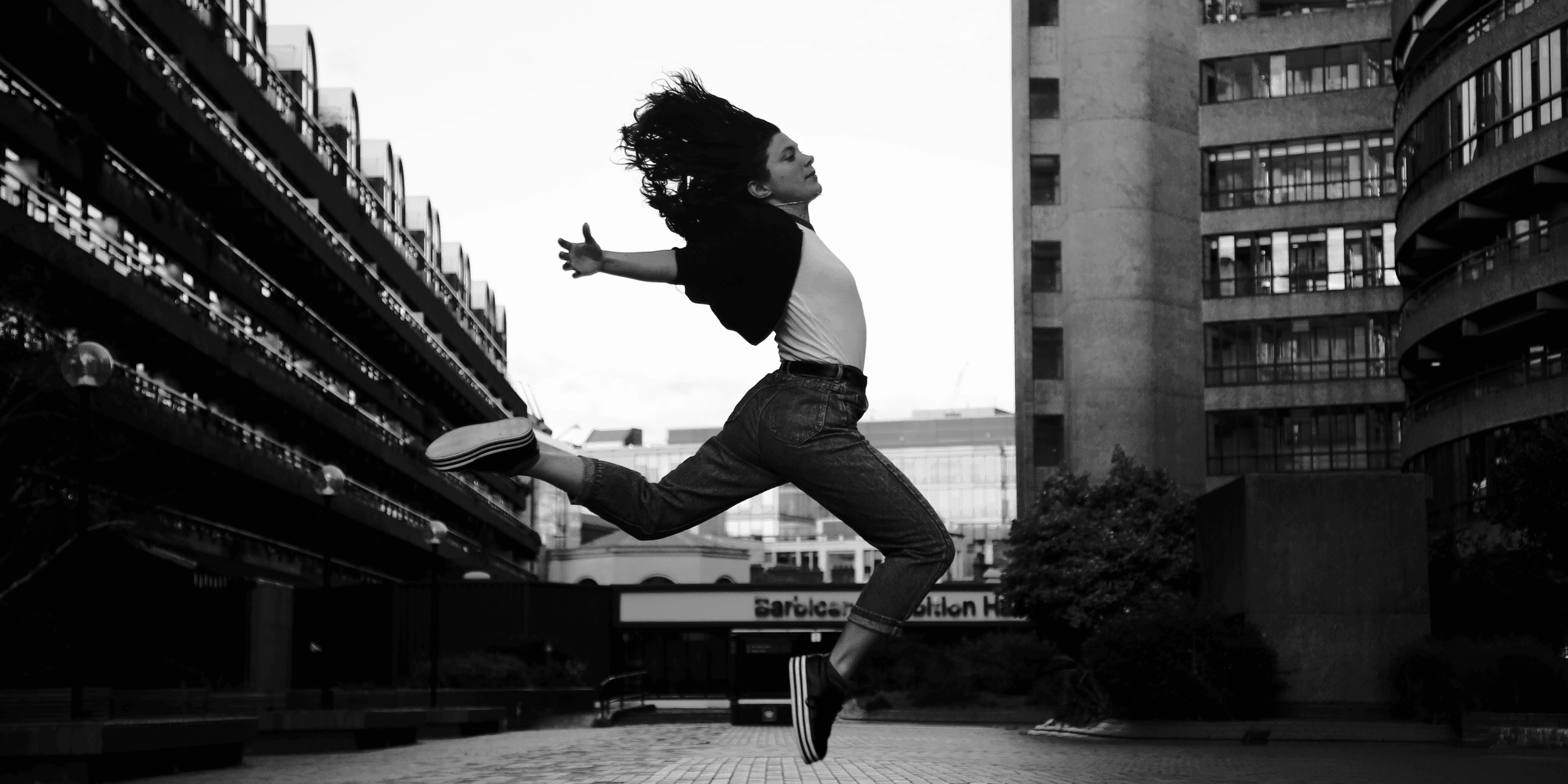 woman jumps on grayscale photography.