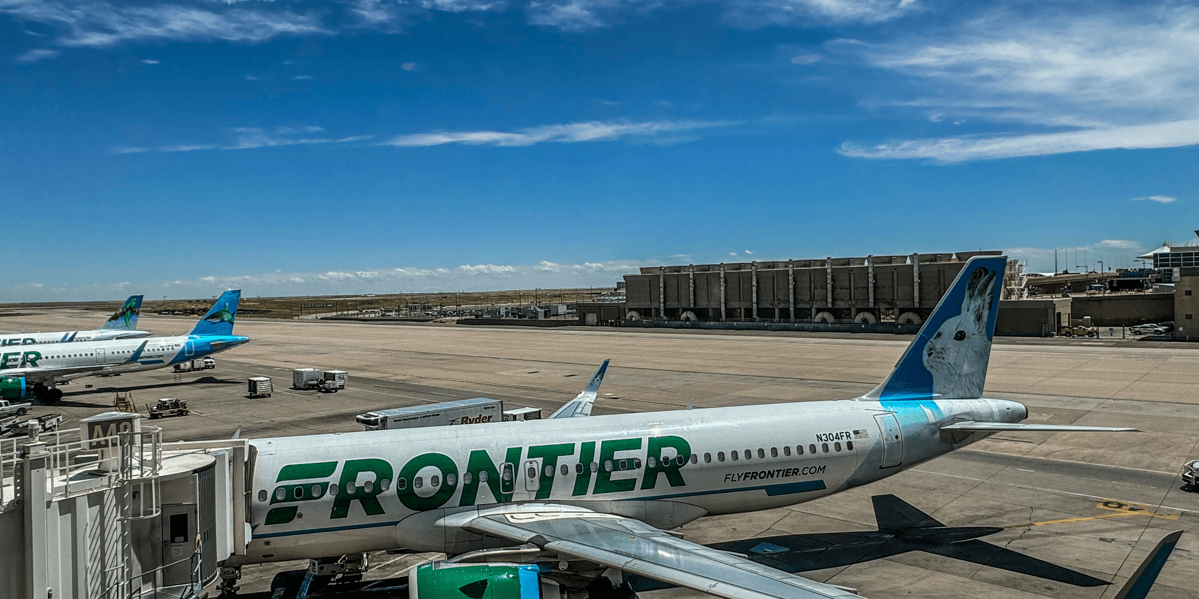 A frontier airplane parked on the tarmac at an airport.