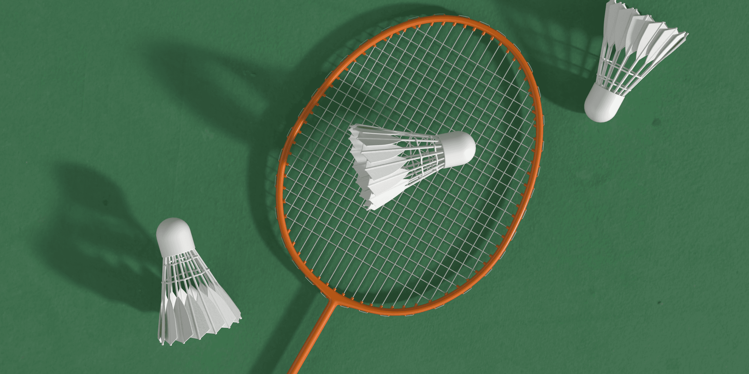 a badminton racket and two shuttles on a green surface.