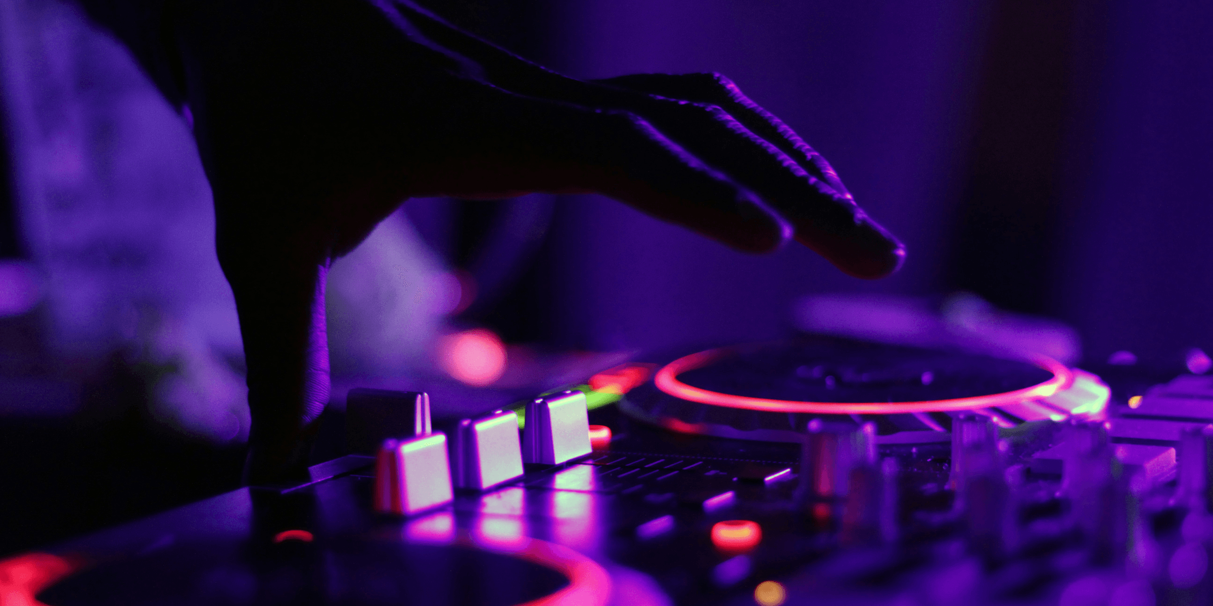 selective focus silhouette photography of man playing red-lighted DJ terminal.