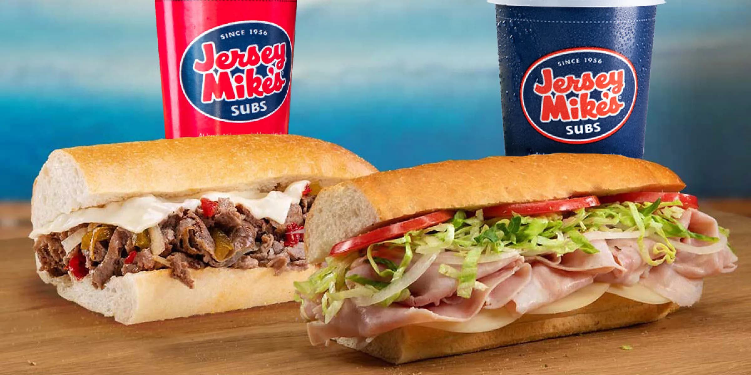 2 sub sandwiches and 2 drinks on a table