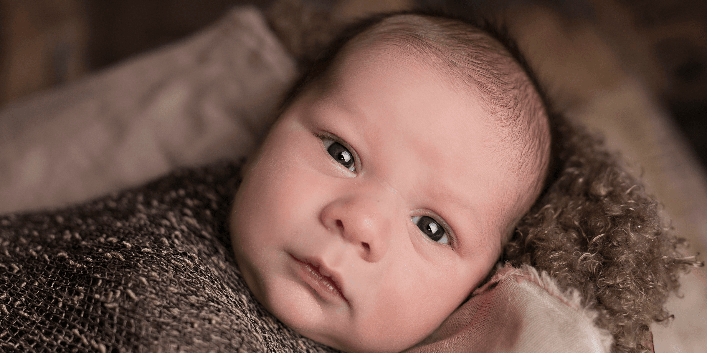 baby in brown swaddle.