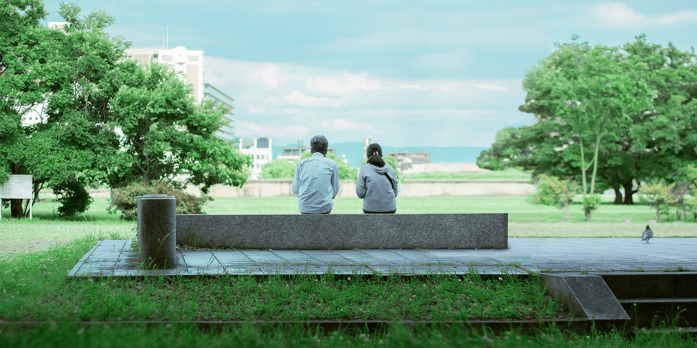 two person sitting on concrete bench.