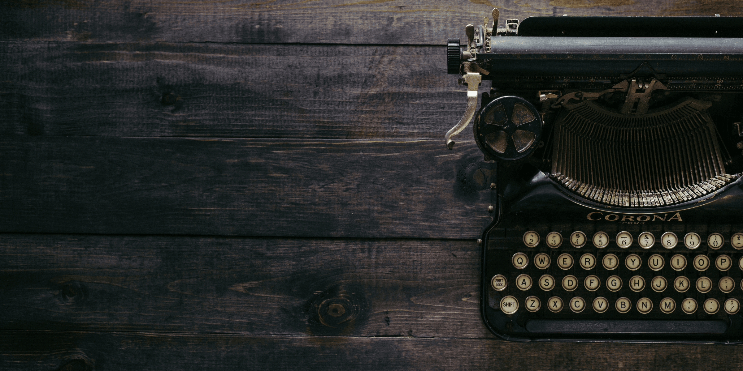 black Corona typewriter on brown wood planks.