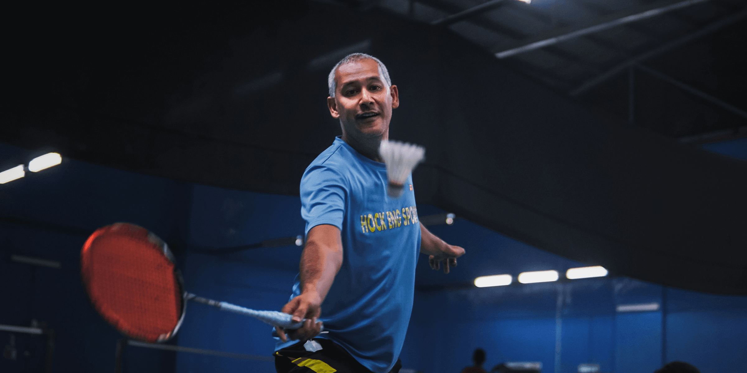 man in blue crew neck t-shirt and black shorts holding red basketball.
