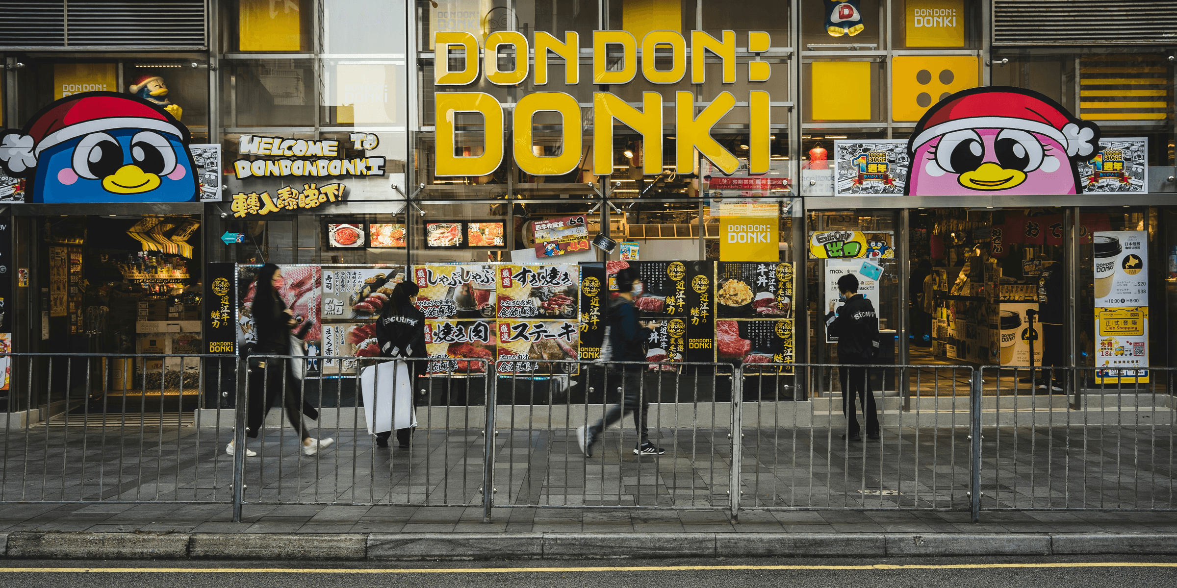 a store front with people walking by on the sidewalk.