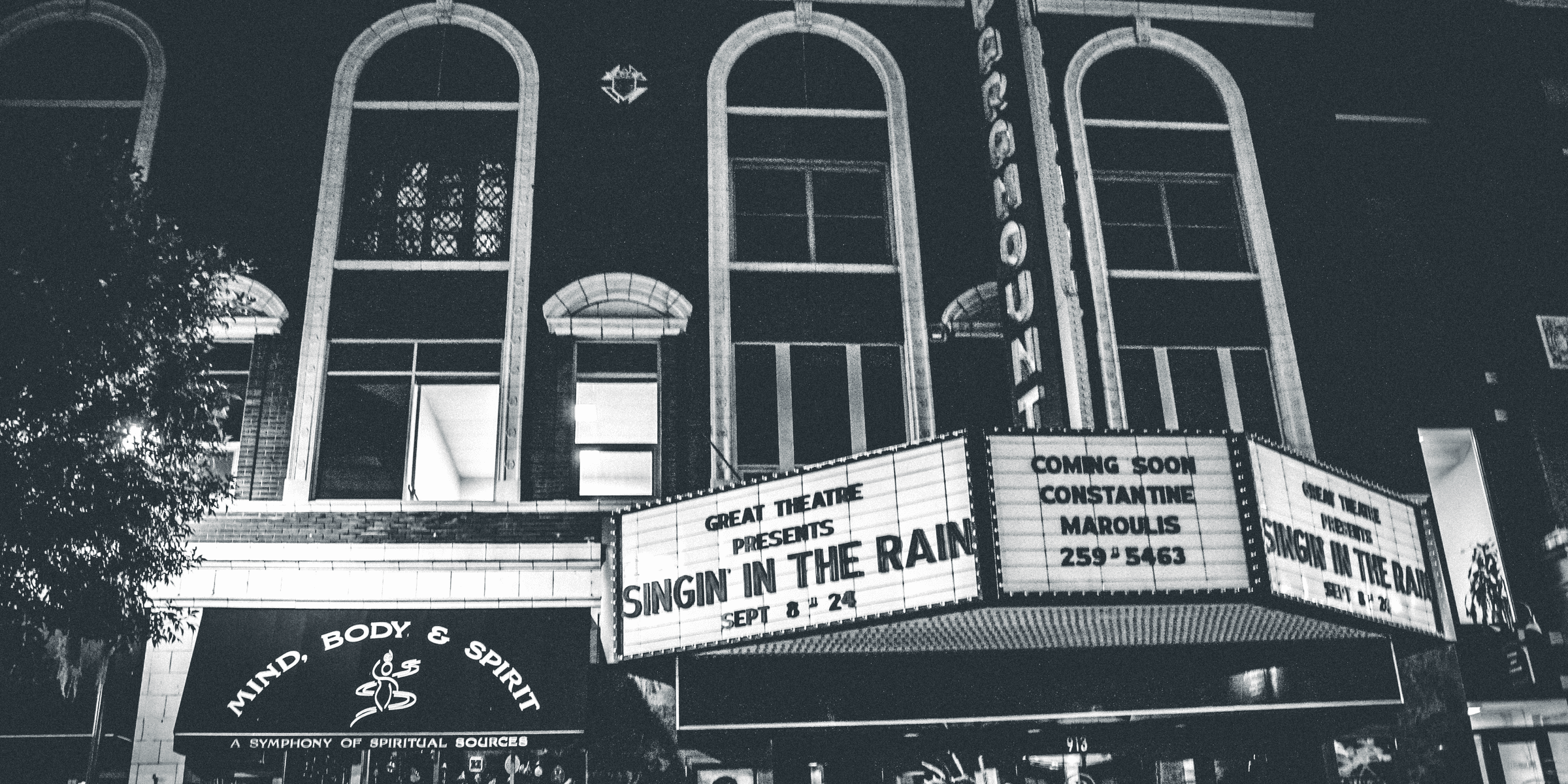 grayscale photo of theater hall with Singin in the Rain movie.
