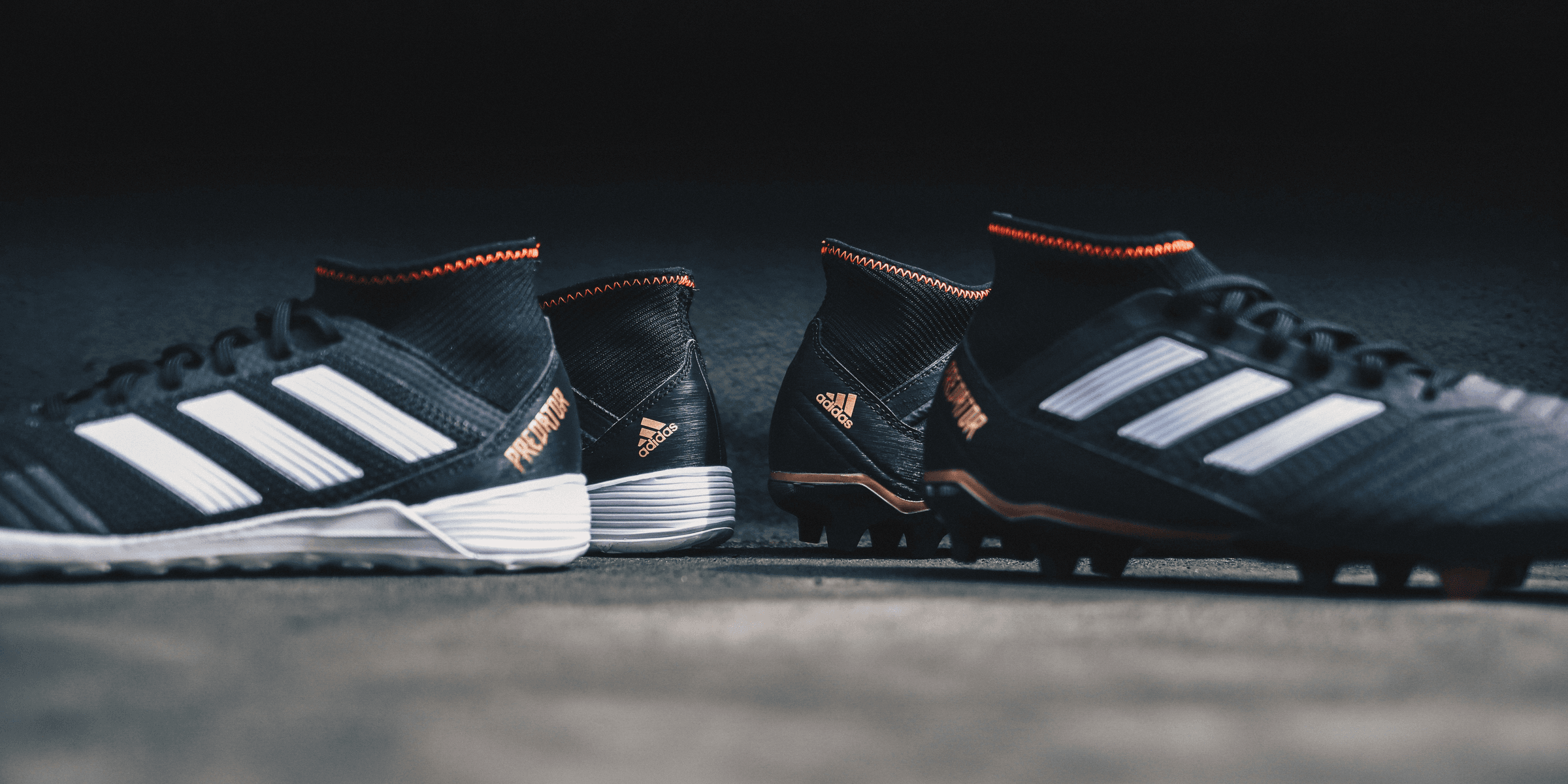 pair of black Adidas cleats.