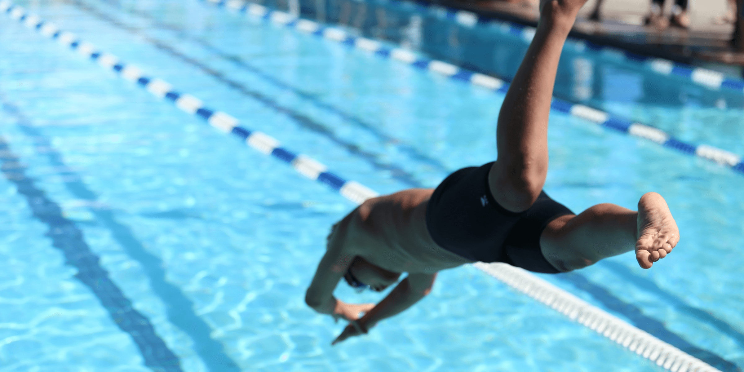 woman in black one piece swimsuit jumping on swimming pool during daytime.