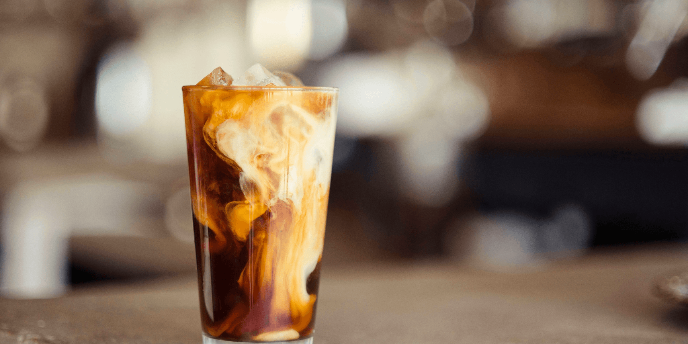 glass cup filled with ice latte on tabletop.