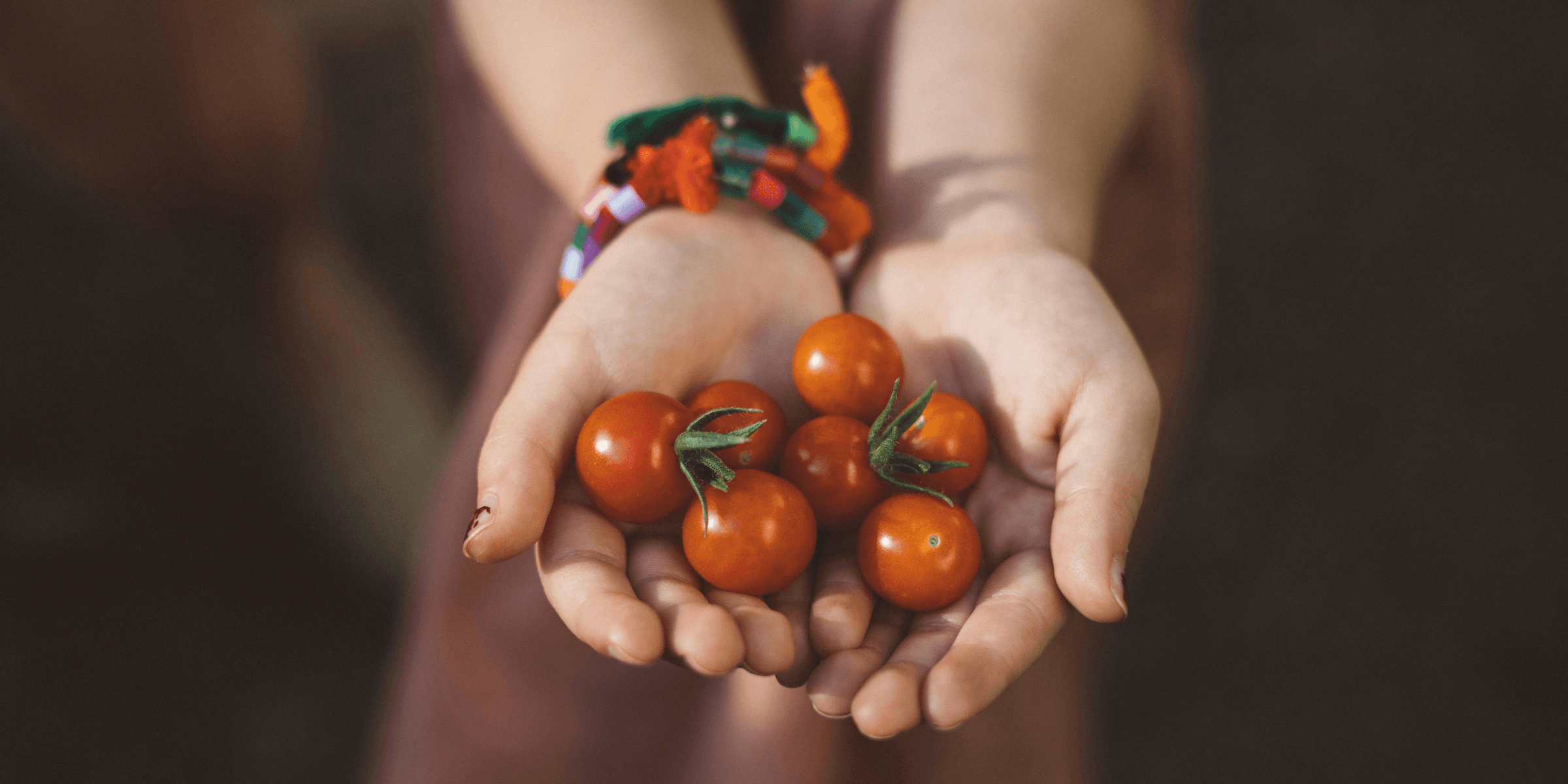 woman with handful of cherry tomatoes.