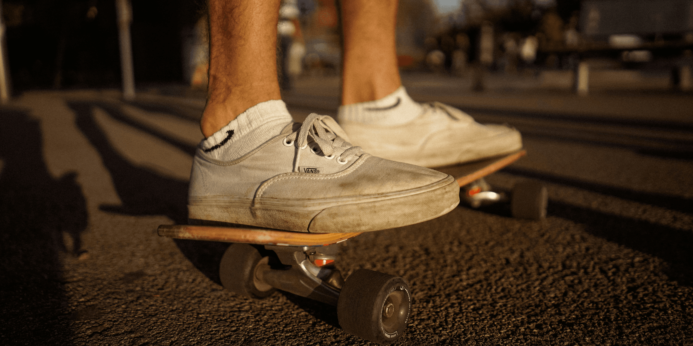 person on top of skateboard on gray pavement.