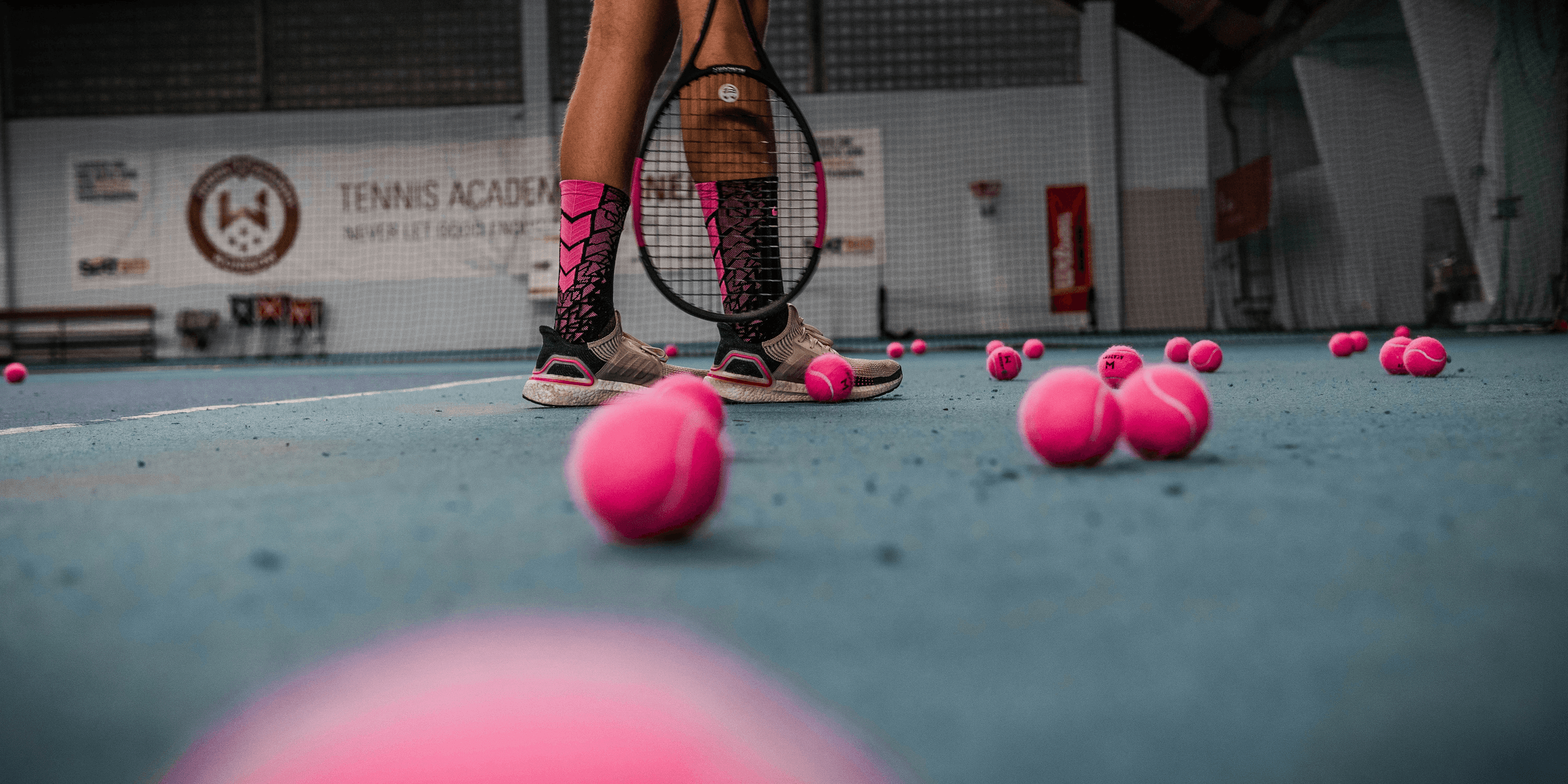 a person standing on a tennis court with a racket.