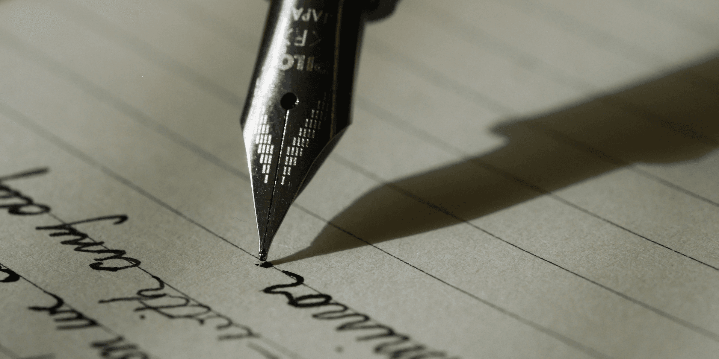 fountain pen on black lined paper.
