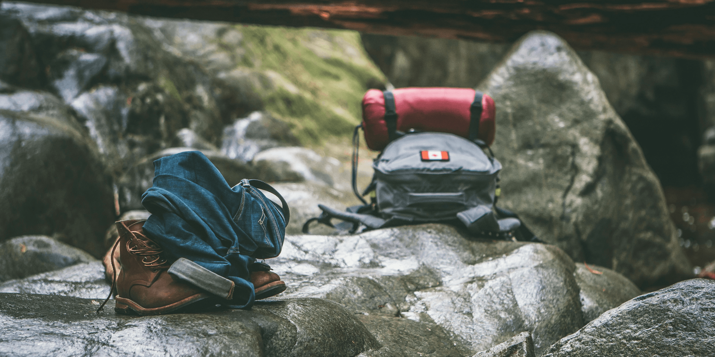 two gray and orange backpacks on gray rocks at daytime.