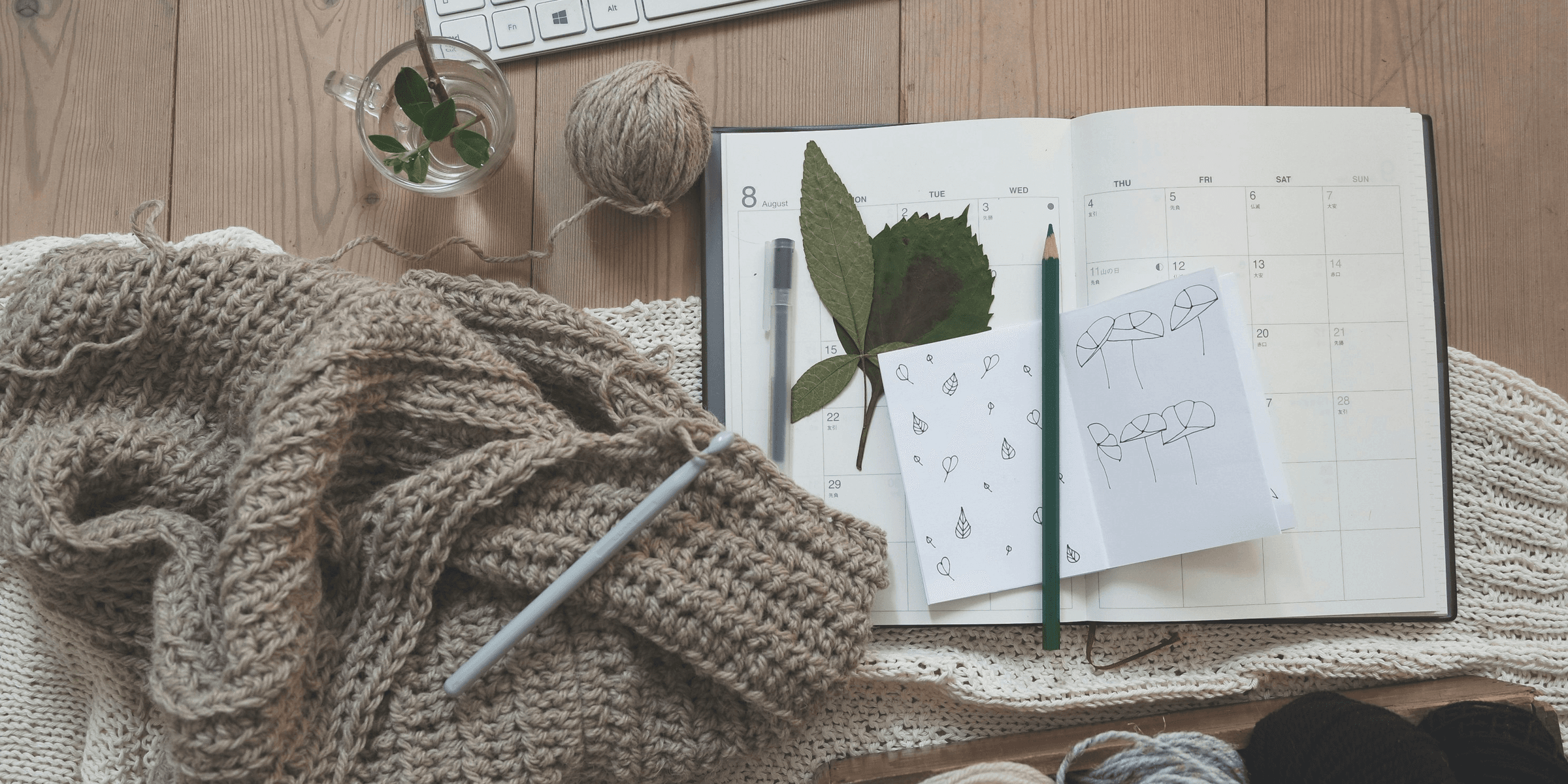 black pencil on white card beside brown knit textile