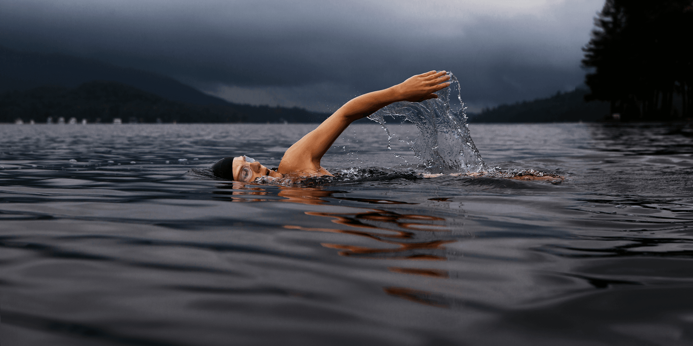 man swimming on body of water.