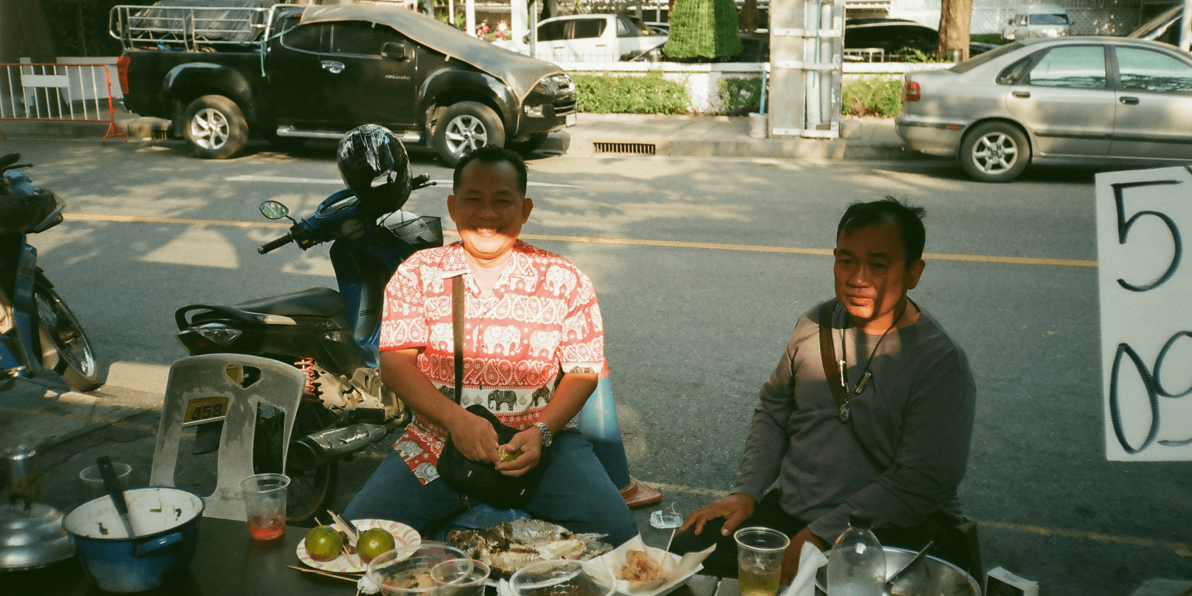 A couple of people sitting at a table with food.