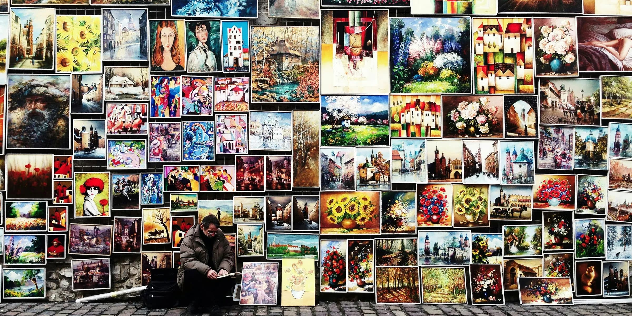 man sitting beside painting lot