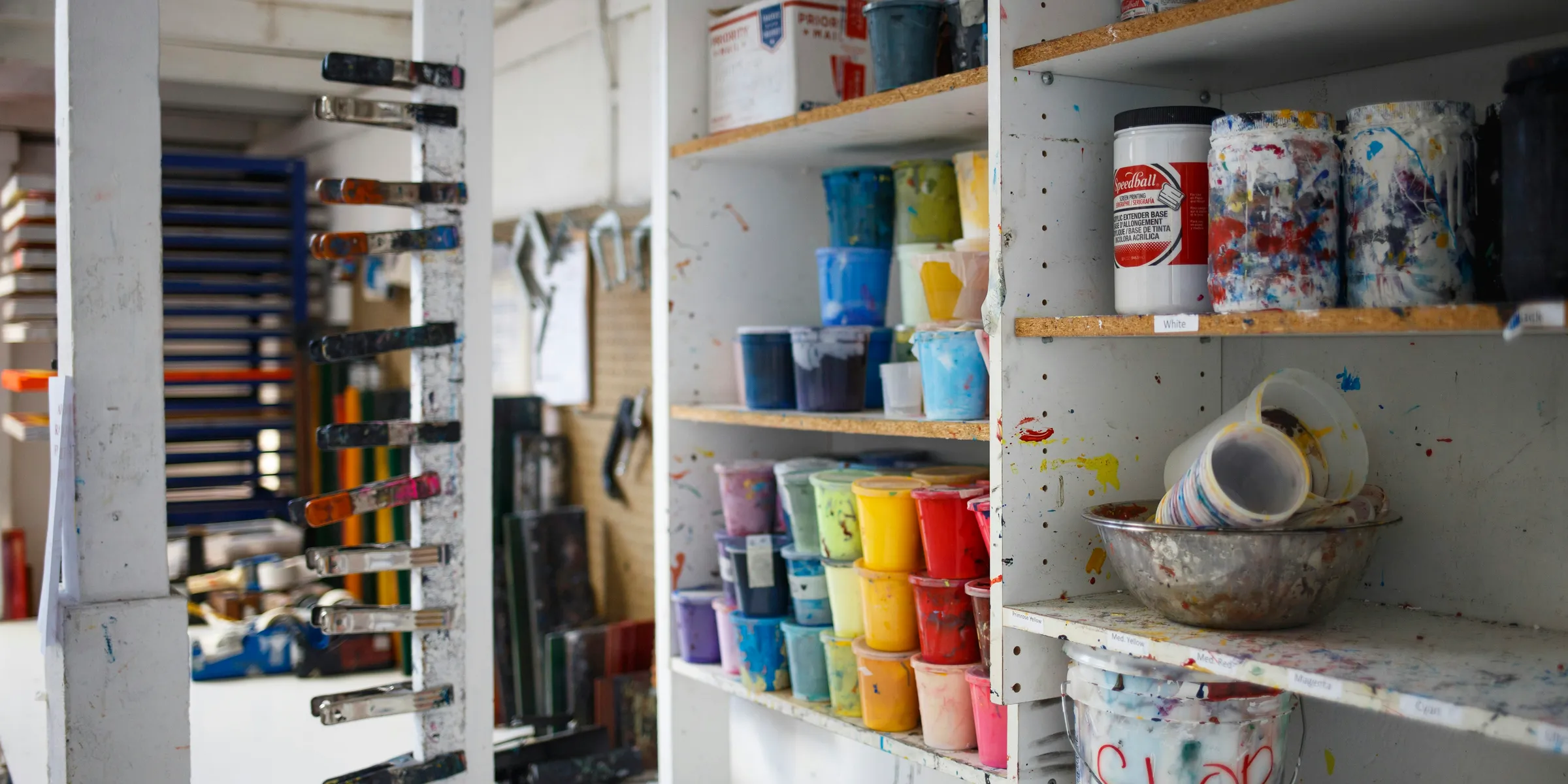 person taking photo of paint containers on display rack