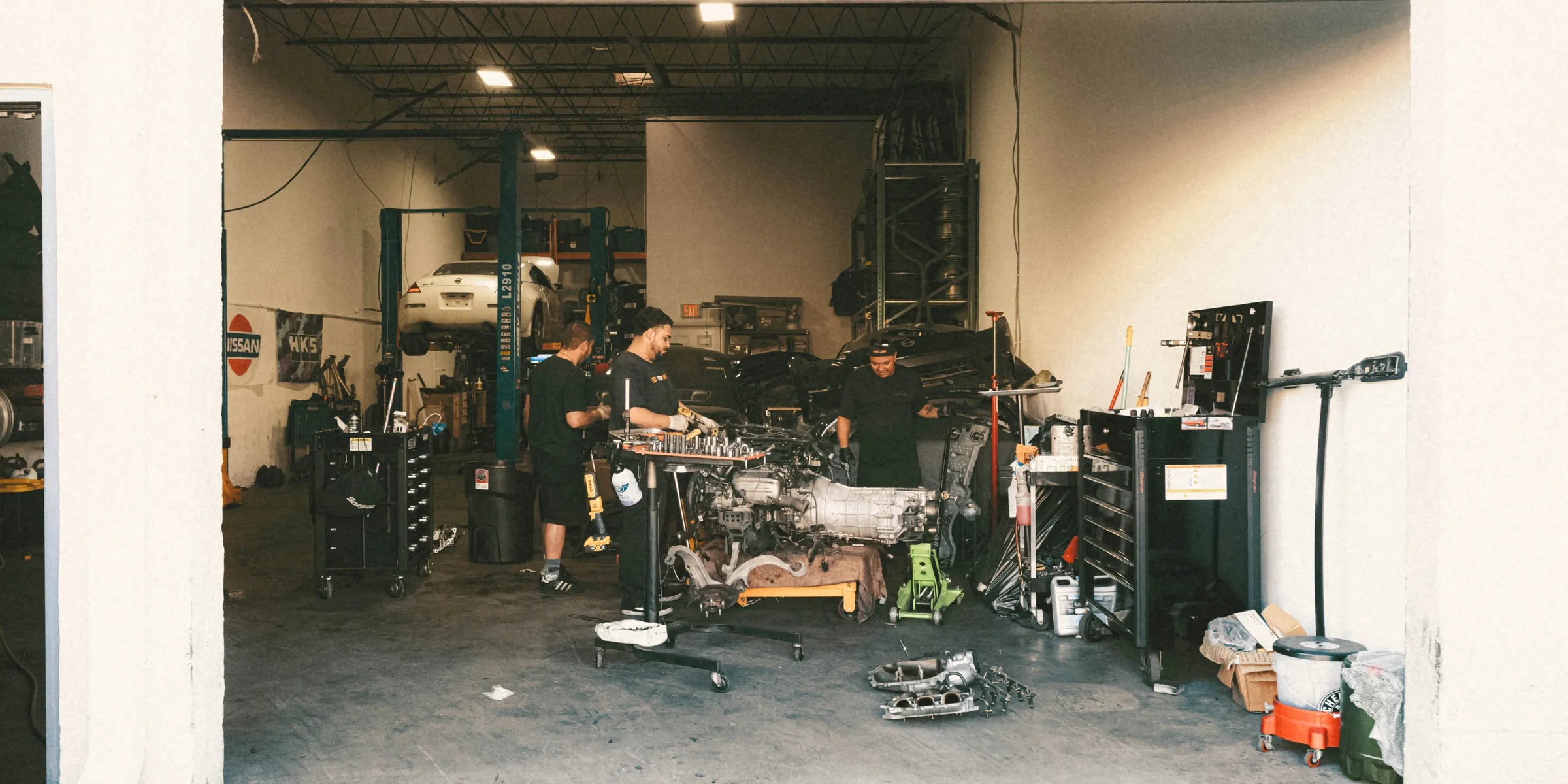 a group of men standing in a garage next to each other