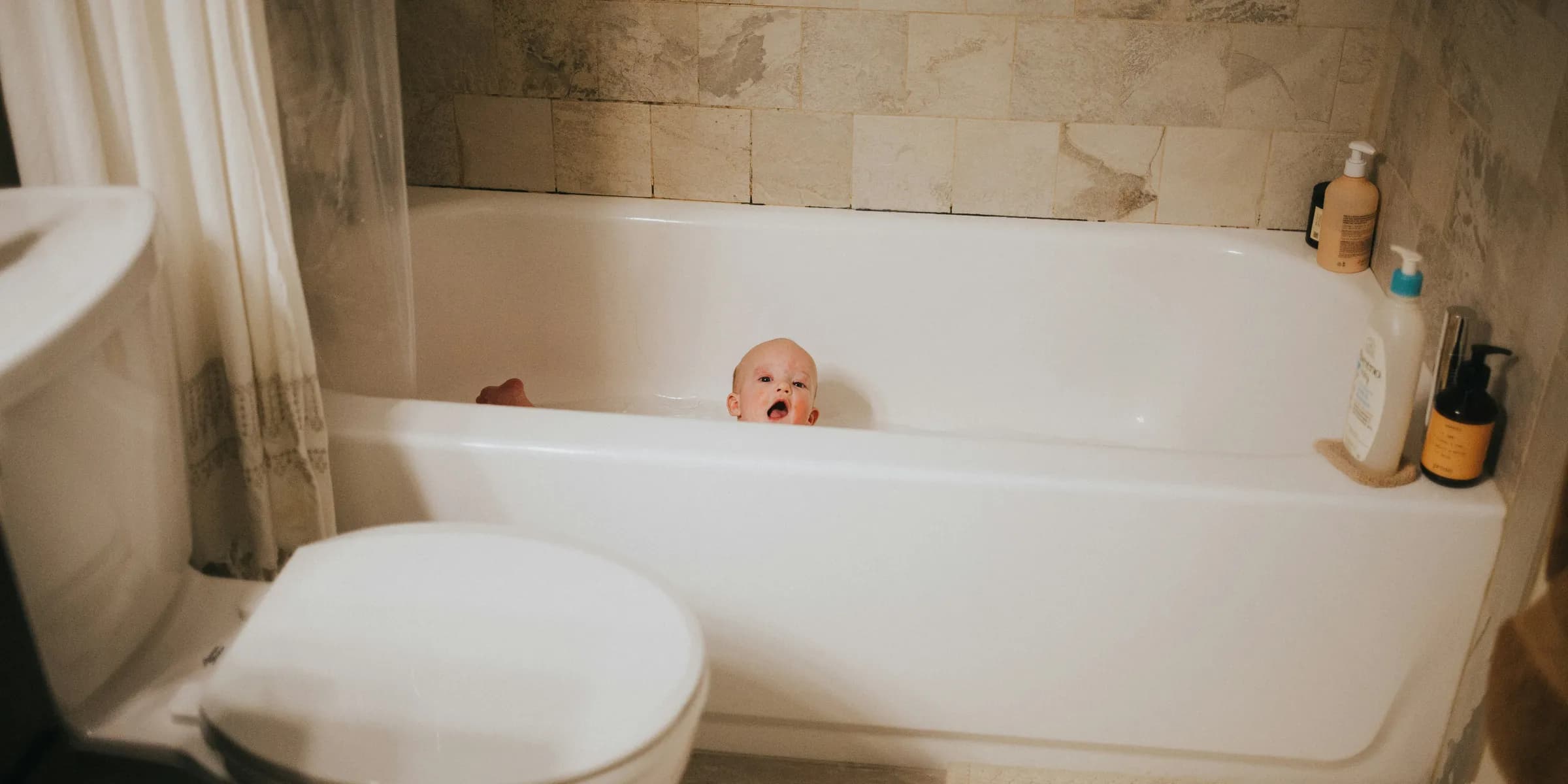 a baby is sitting in a bathtub in a bathroom