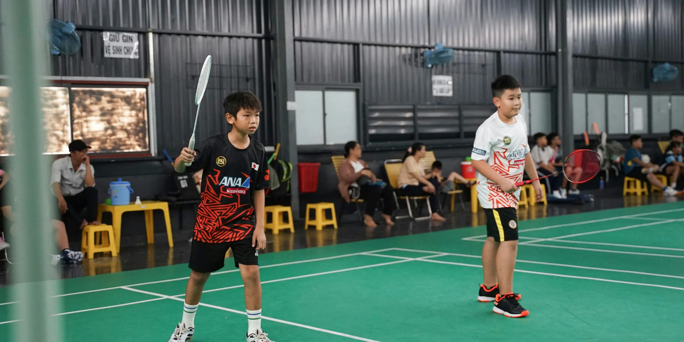 a couple of young men standing on top of a tennis court
