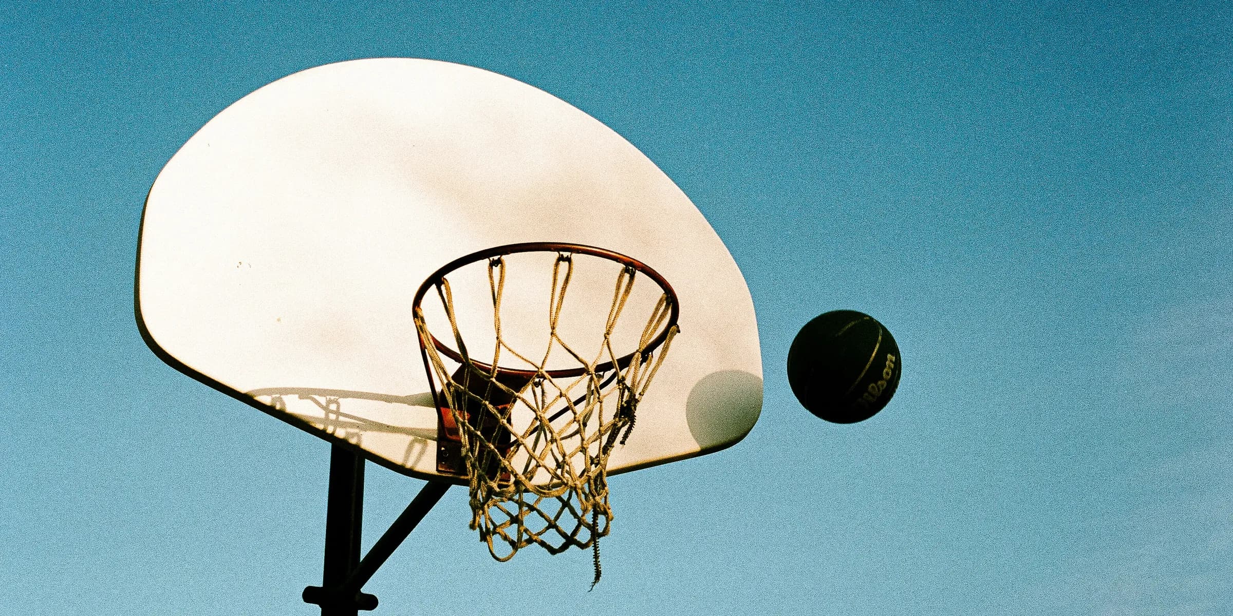 A basketball going through the basket of a basketball hoop