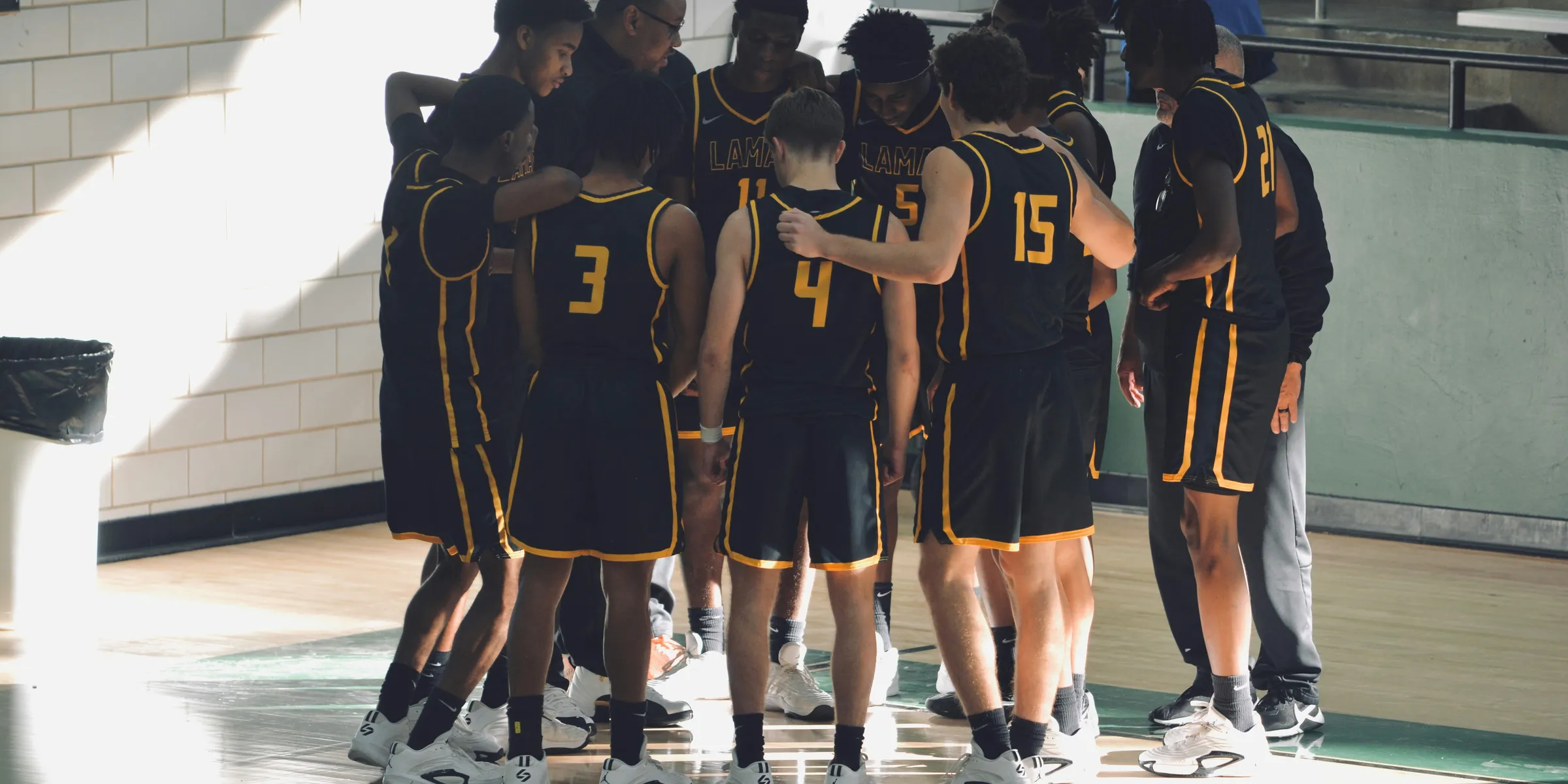 A group of young men standing on top of a basketball court