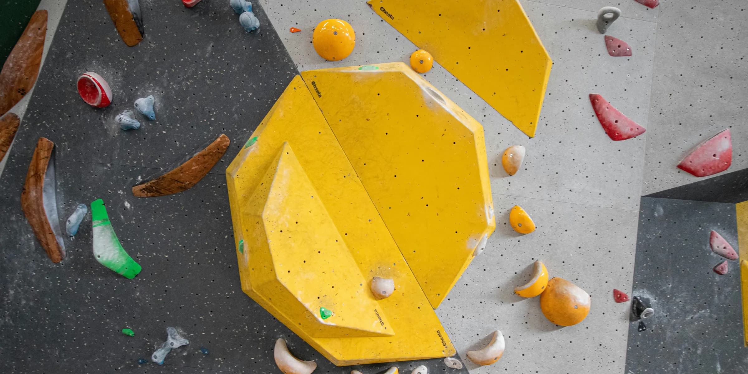a rock climbing wall with a yellow climbing device