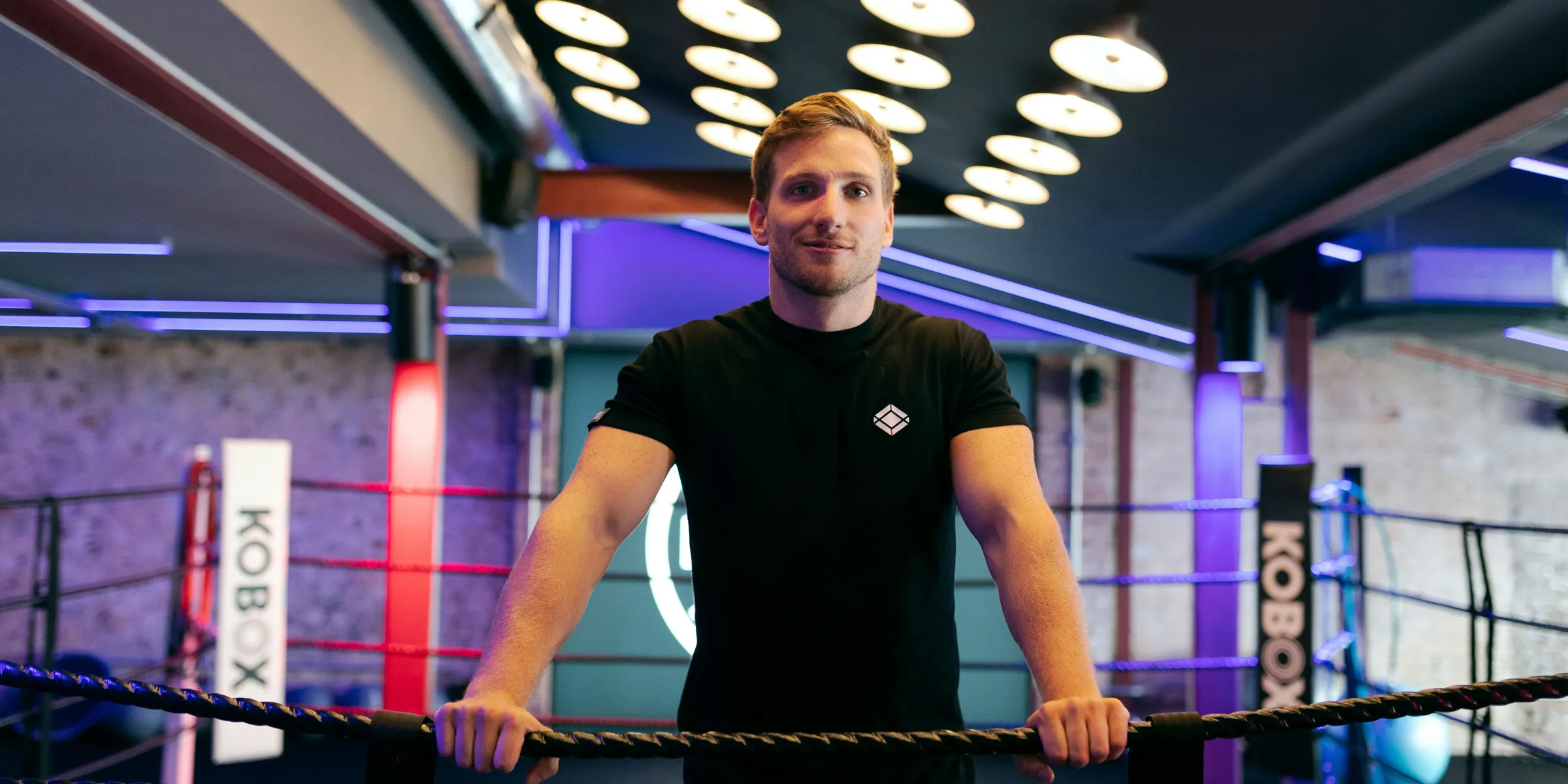 man in black crew neck t-shirt standing and smiling