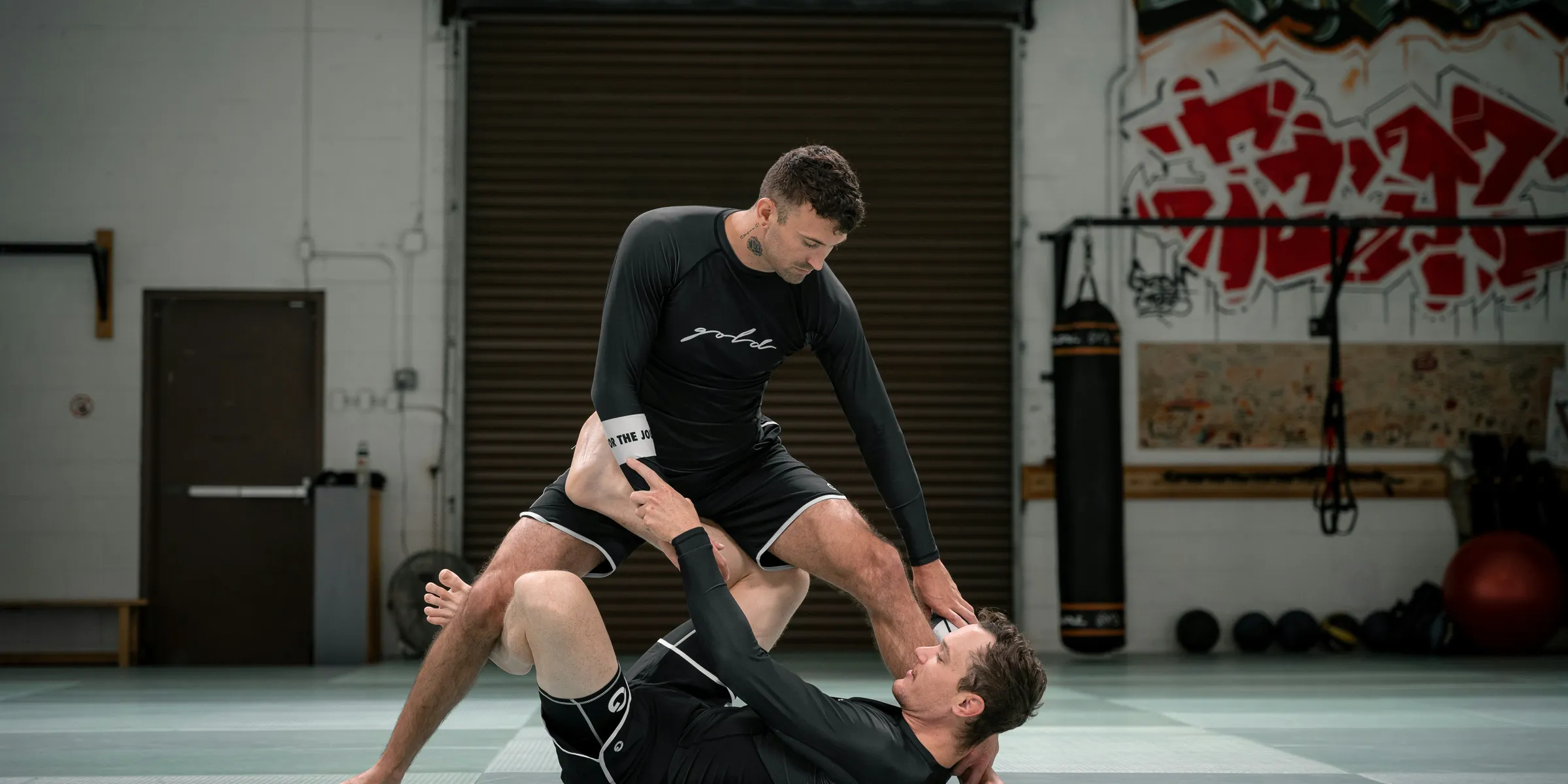 a couple of men standing on top of each other in a gym