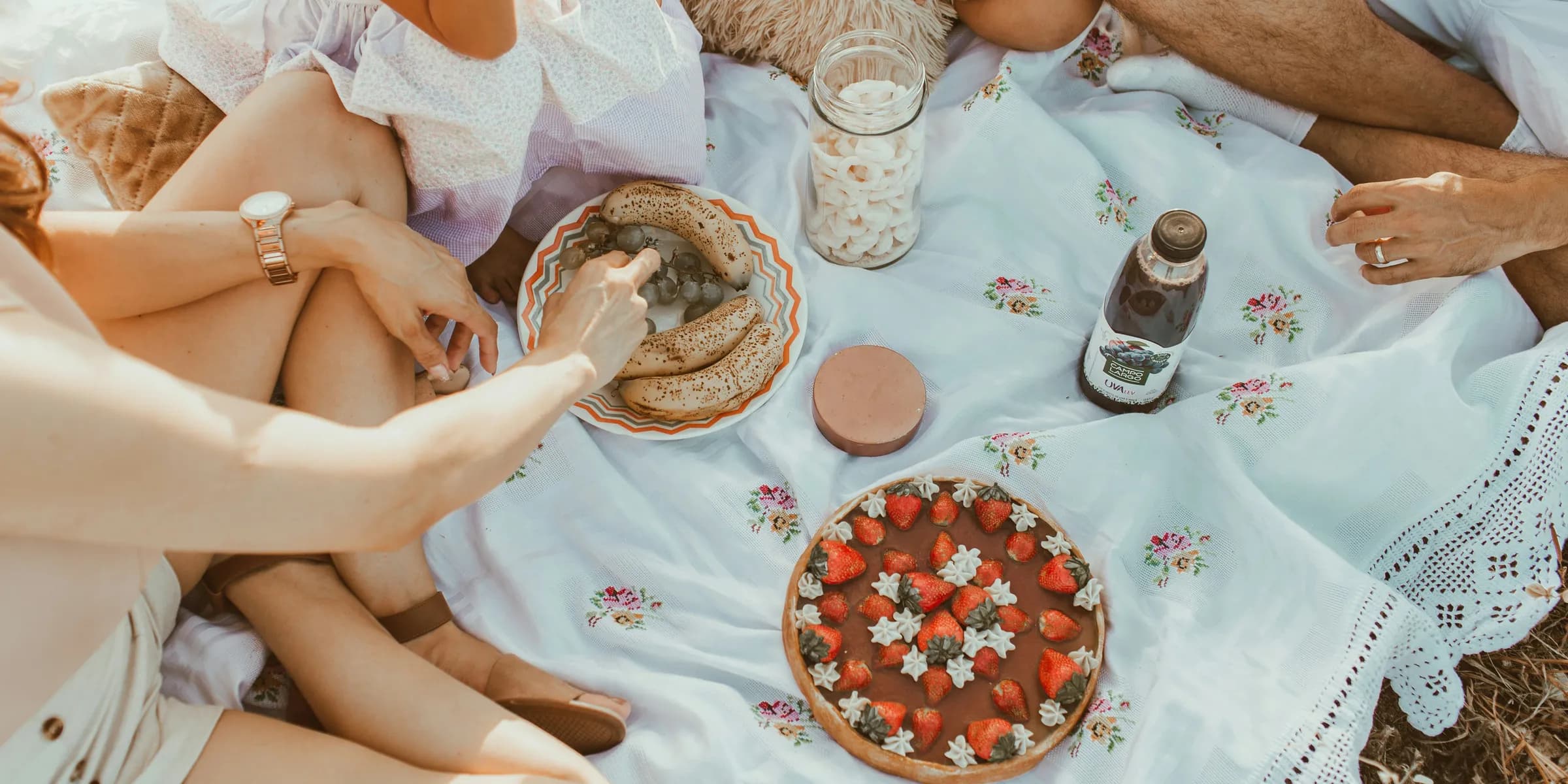 people sitting on white textile eating bread near cake