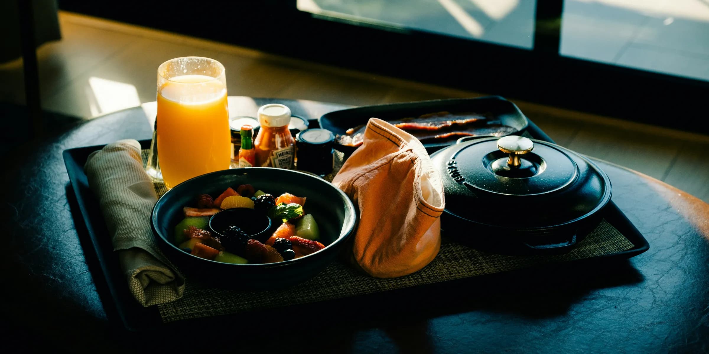 a tray of food on a table with a glass of orange juice
