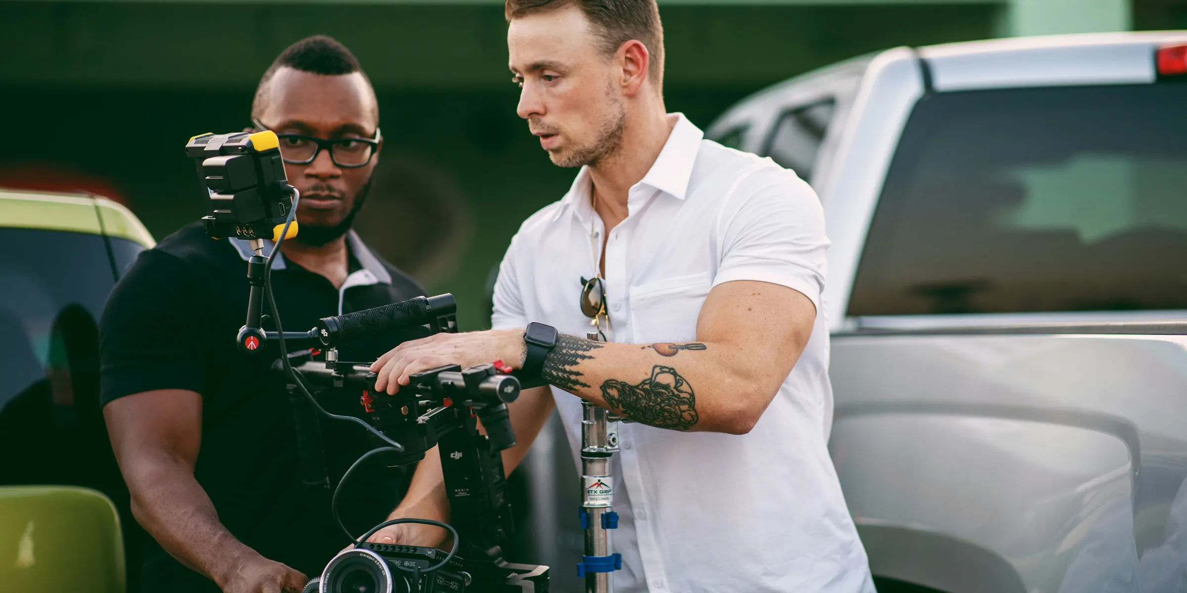 man in white button up shirt holding black and silver video camera