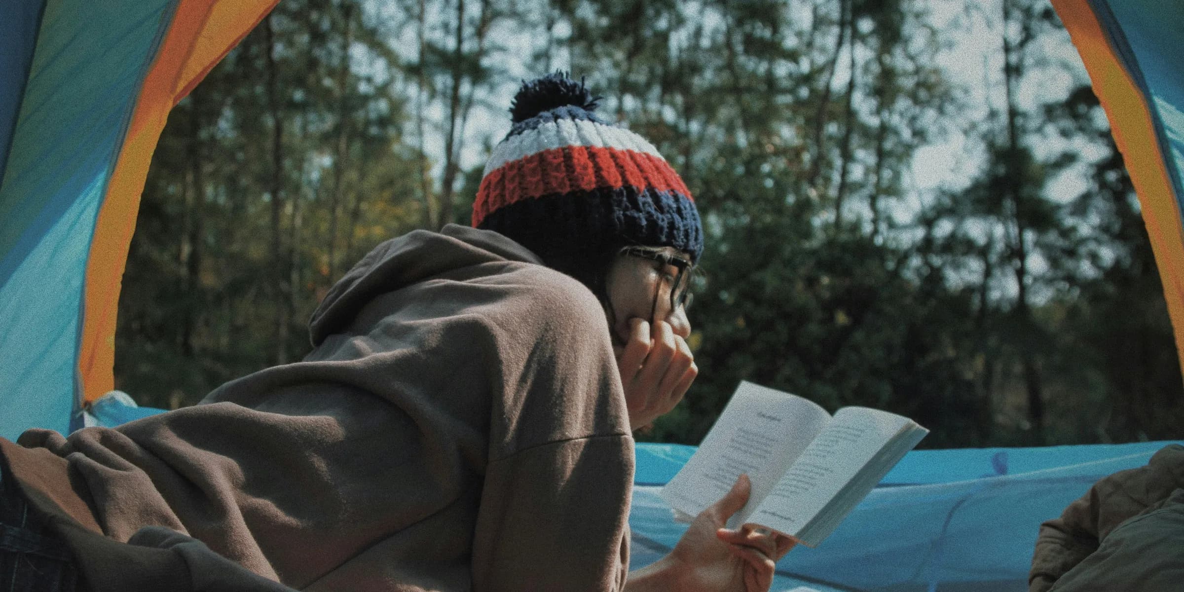 woman reading book in tent