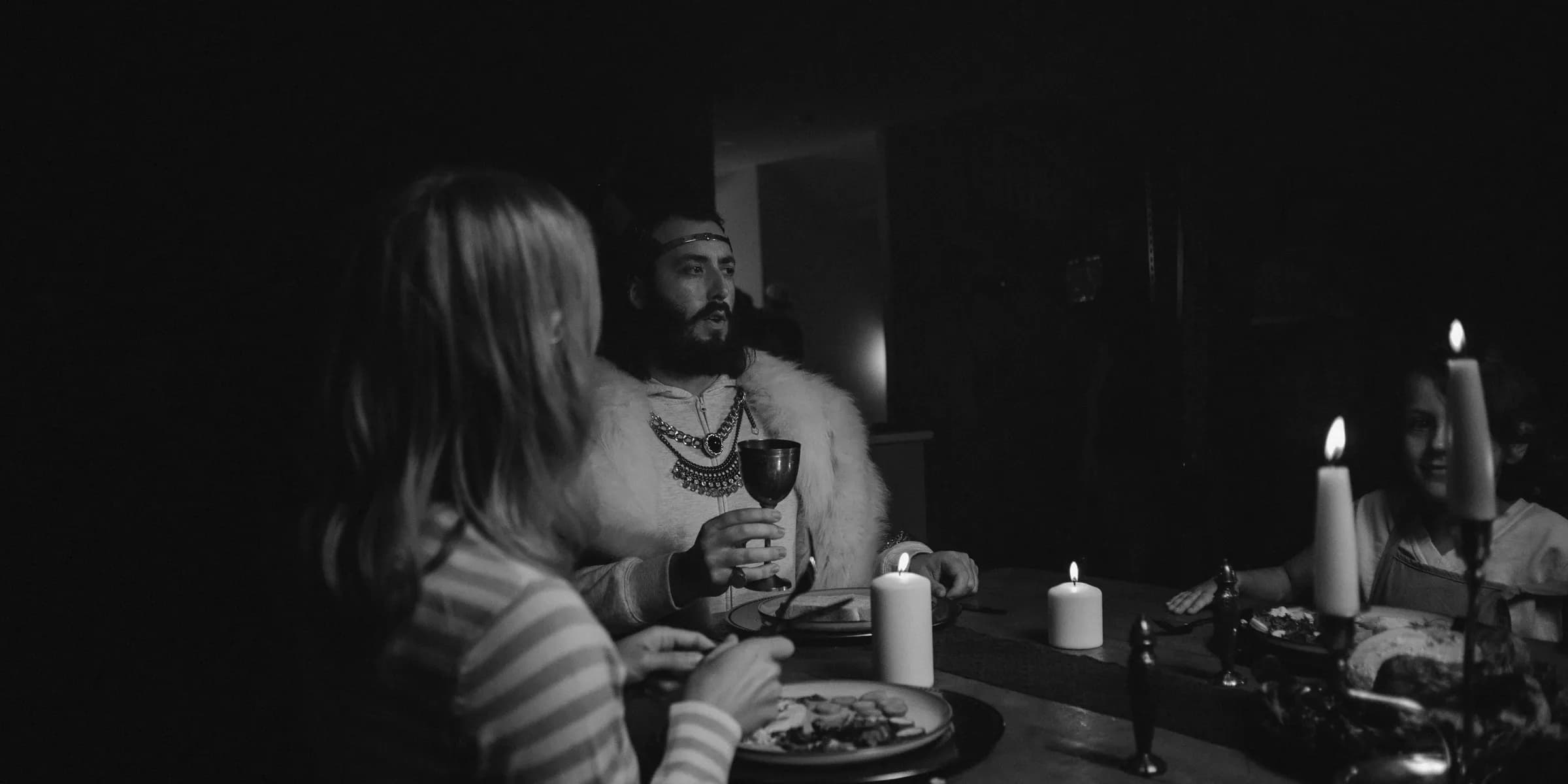 People dining by candlelight in dark room