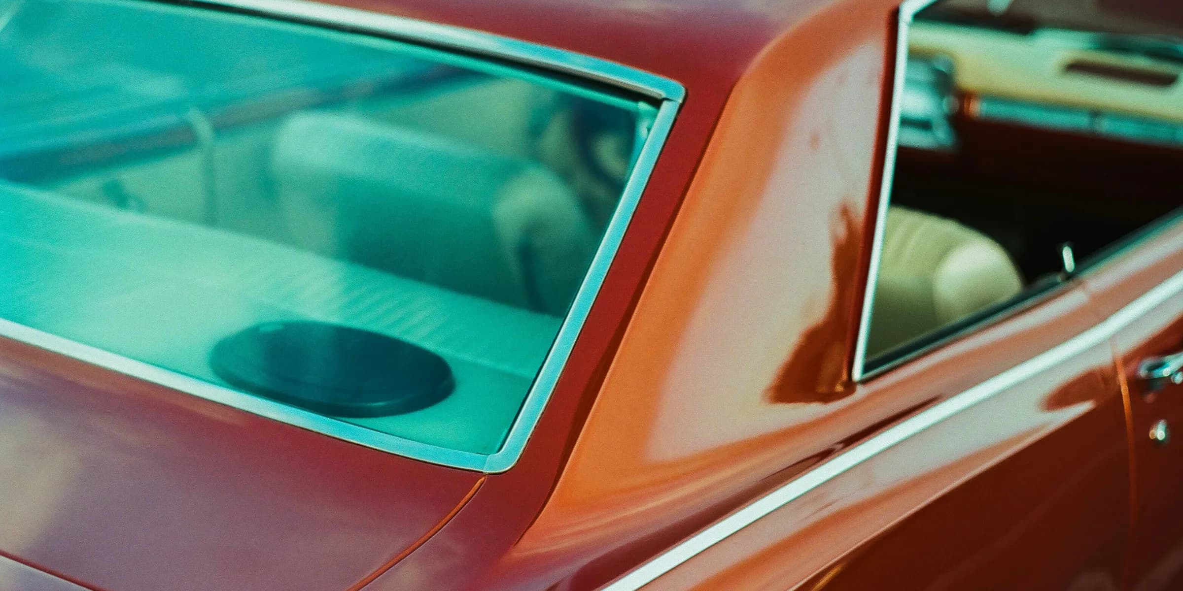a close up of a red car with a person in it