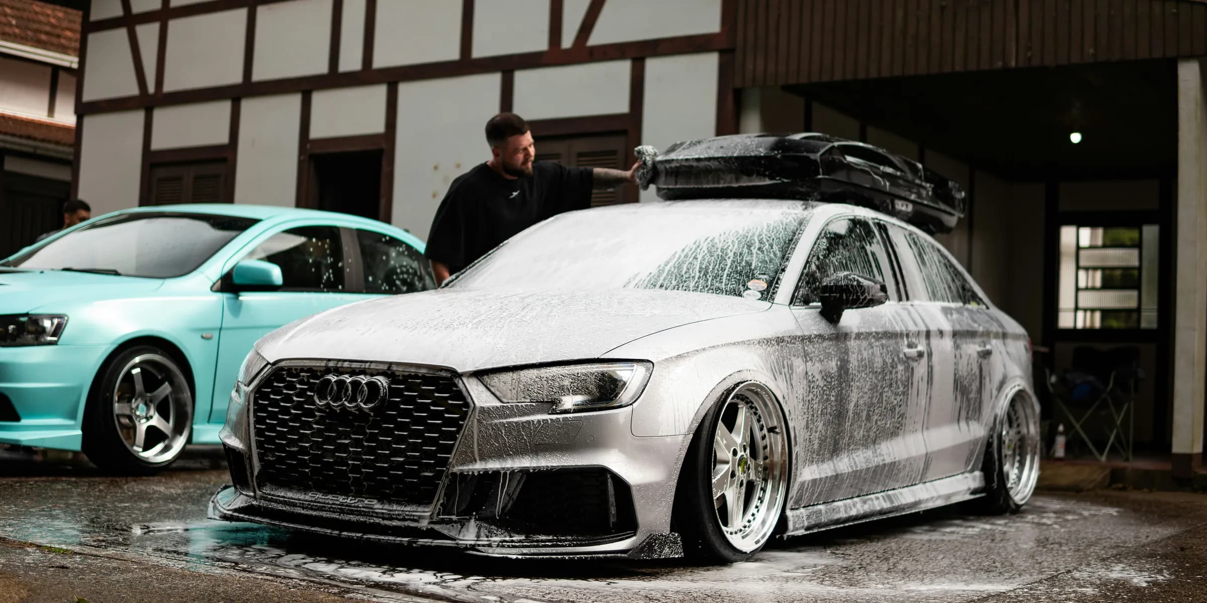 Man washing a silver audi with foam