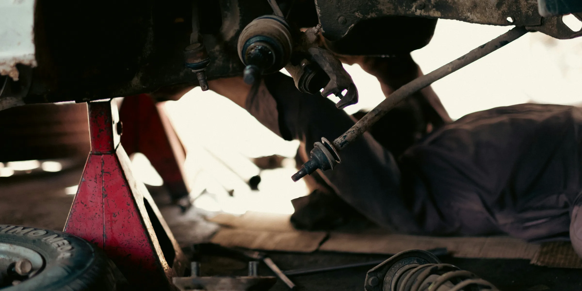 a man working on a car under a vehicle