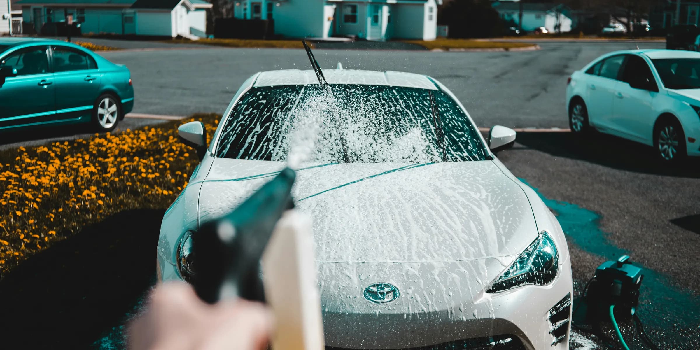 person spraying water on vehicle