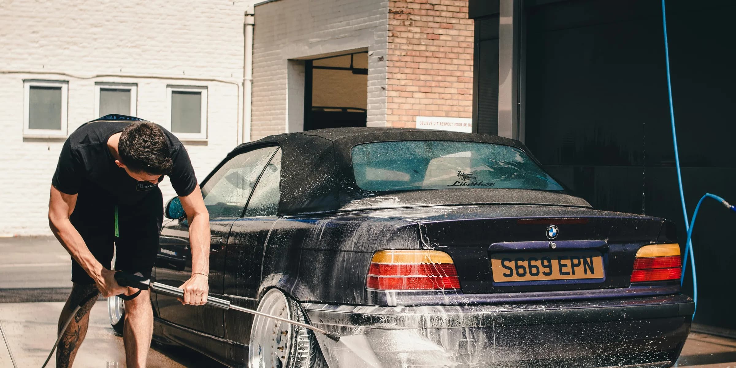 man washing BMW coupe