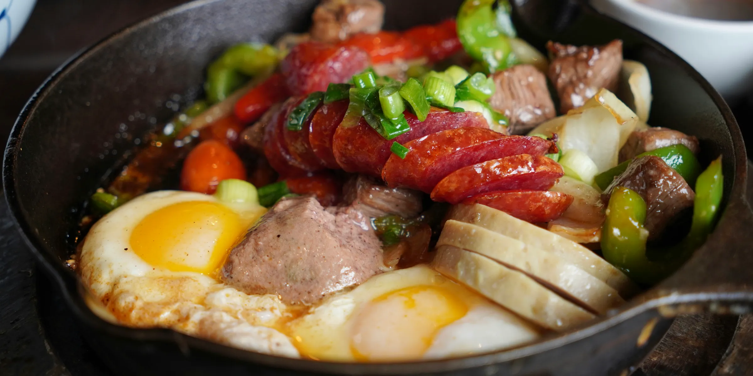 Breakfast skillet with sausage, eggs, and peppers.