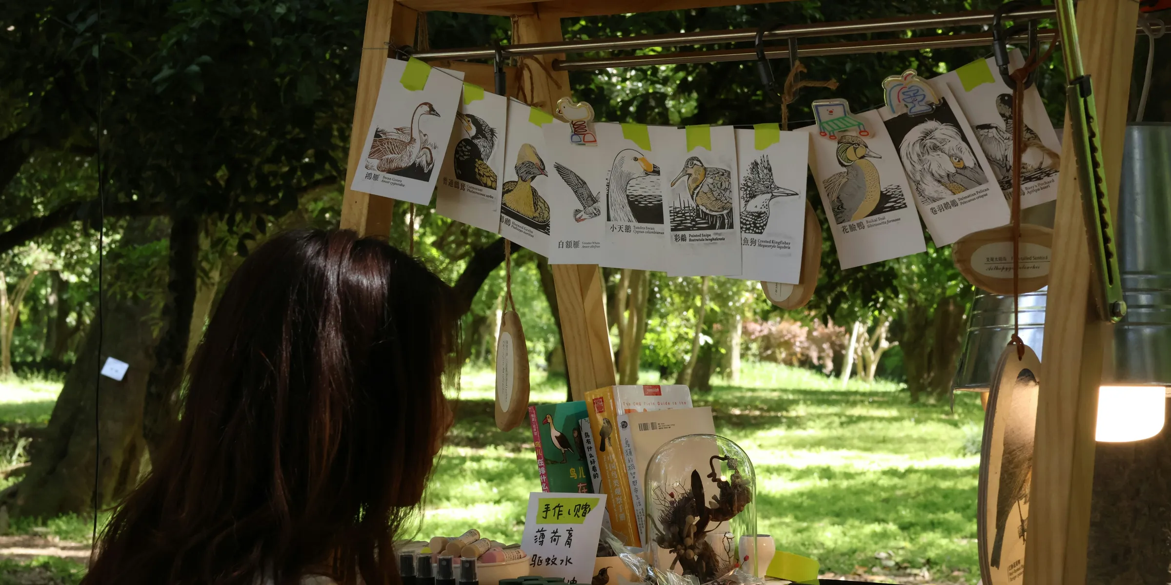 A woman shops at an outdoor art booth.
