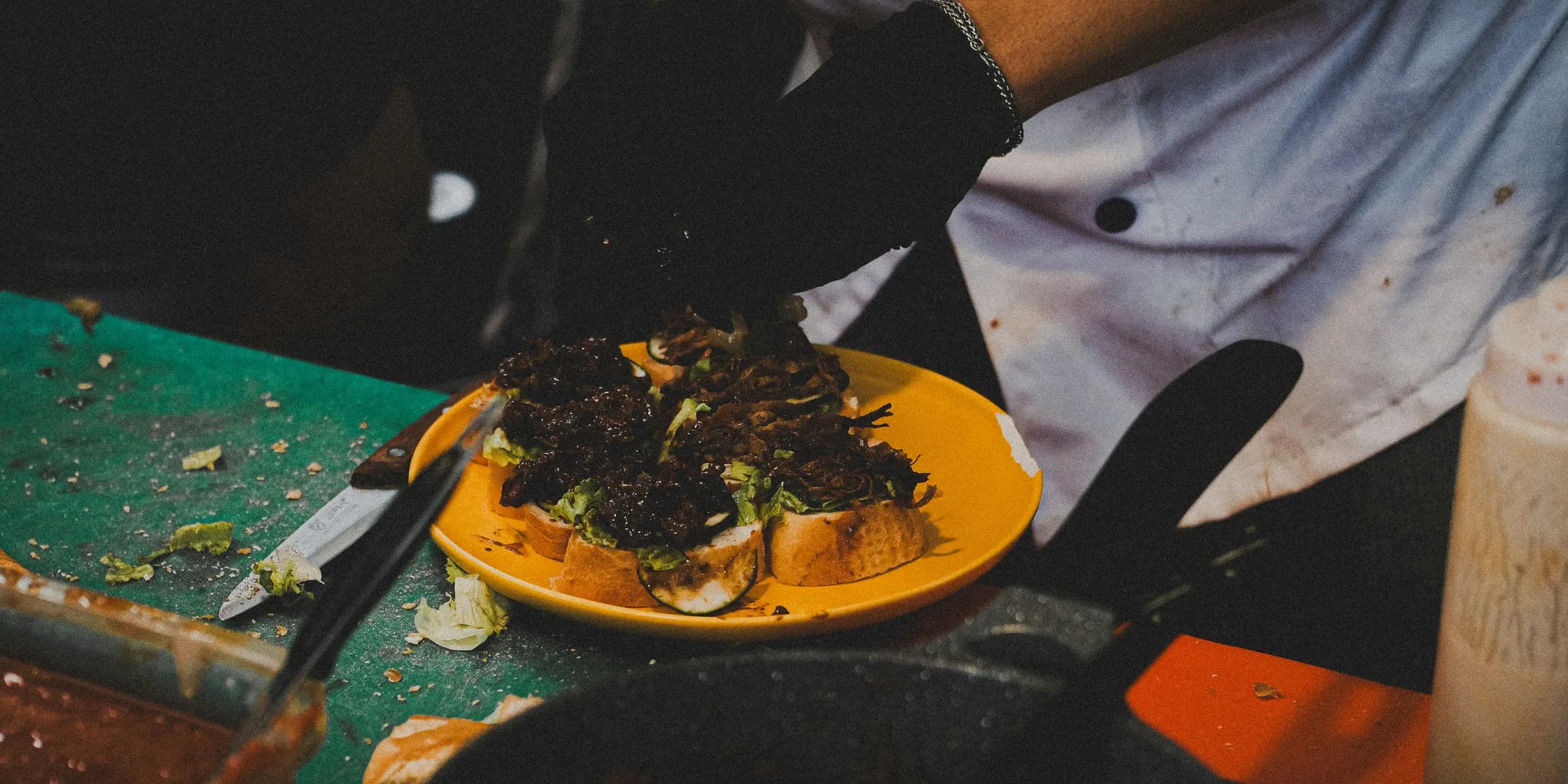 a person in a chef's uniform preparing food on a plate