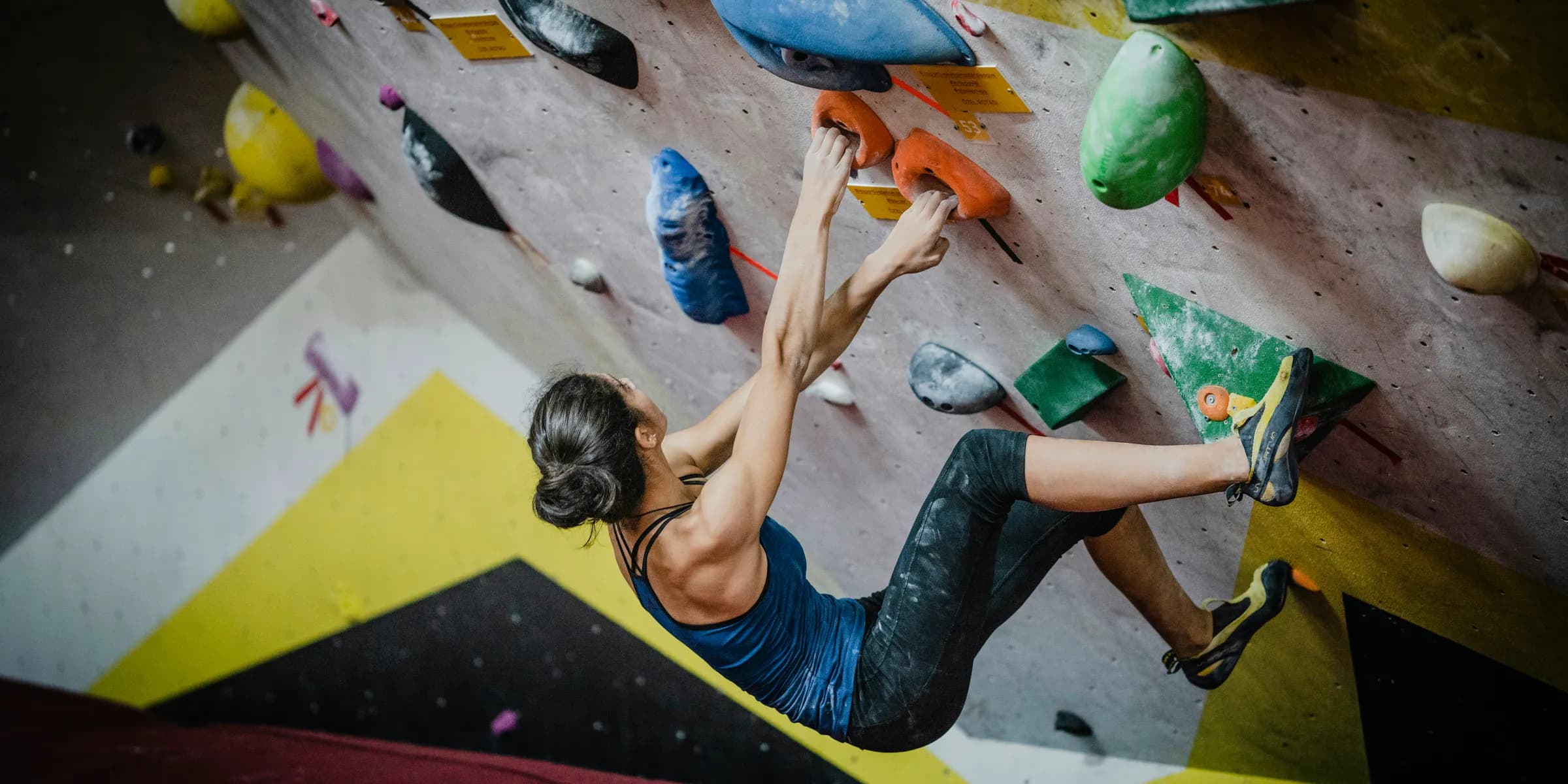 woman rock climbing inside building