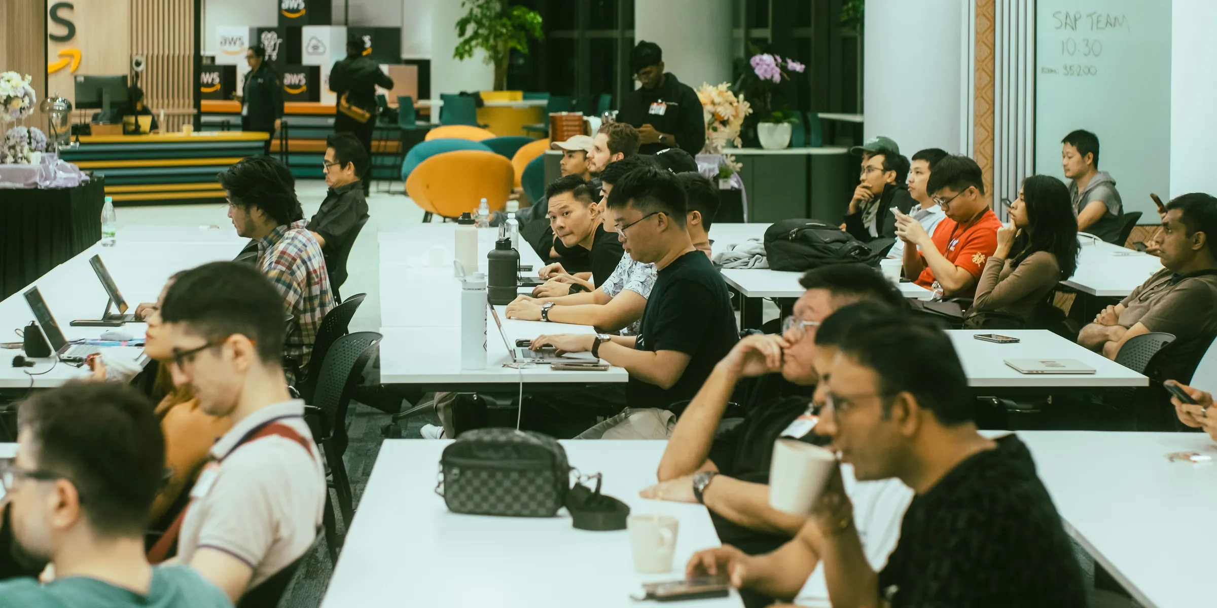 A group of people sitting at tables with laptops